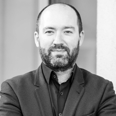 Black and white image of Neil Brady smiling into the camera.