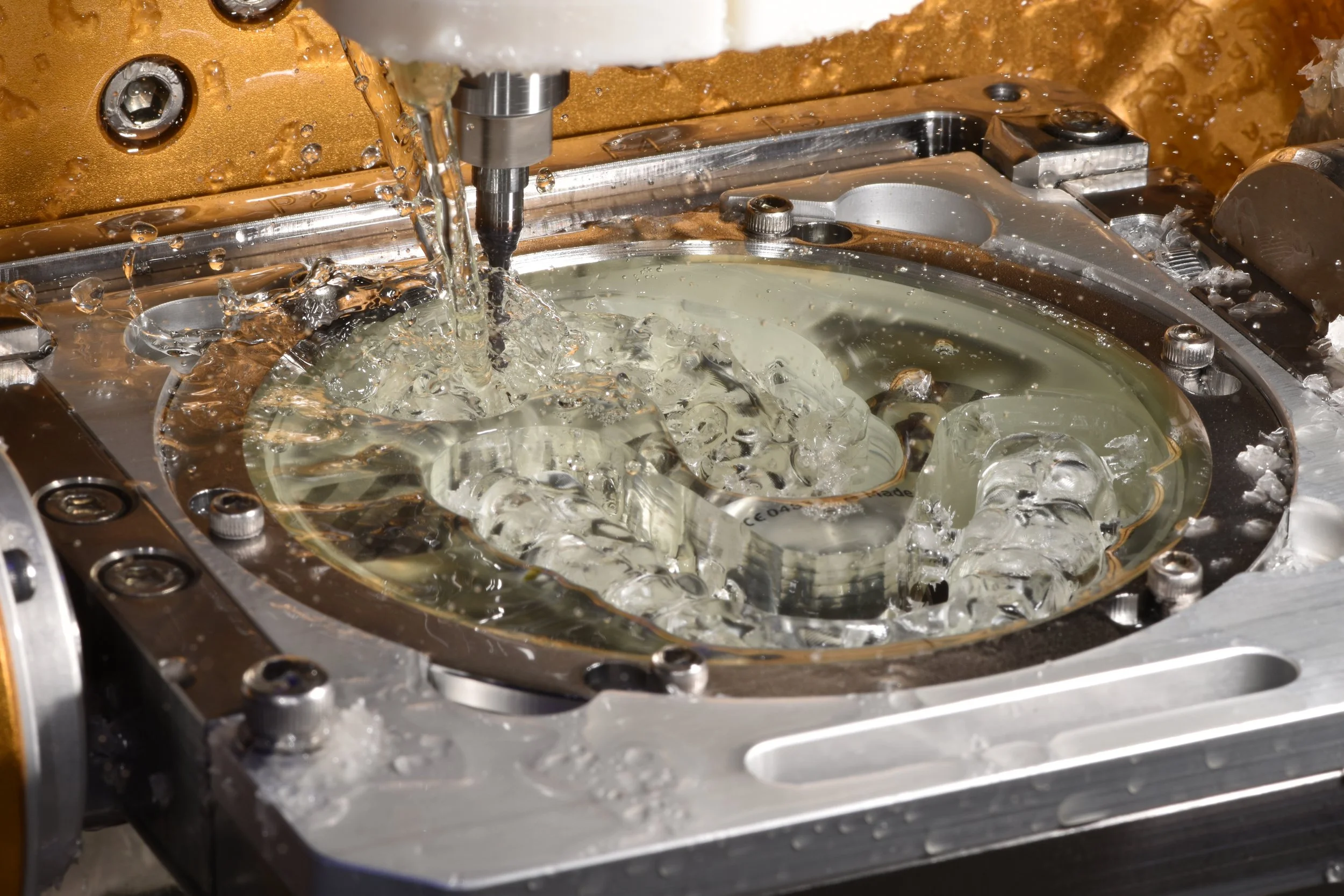 Fräsmaschine bei der Bearbeitung eines Werkstücks, mit Kühlmittelfluss zum Schutz vor Überhitzung.