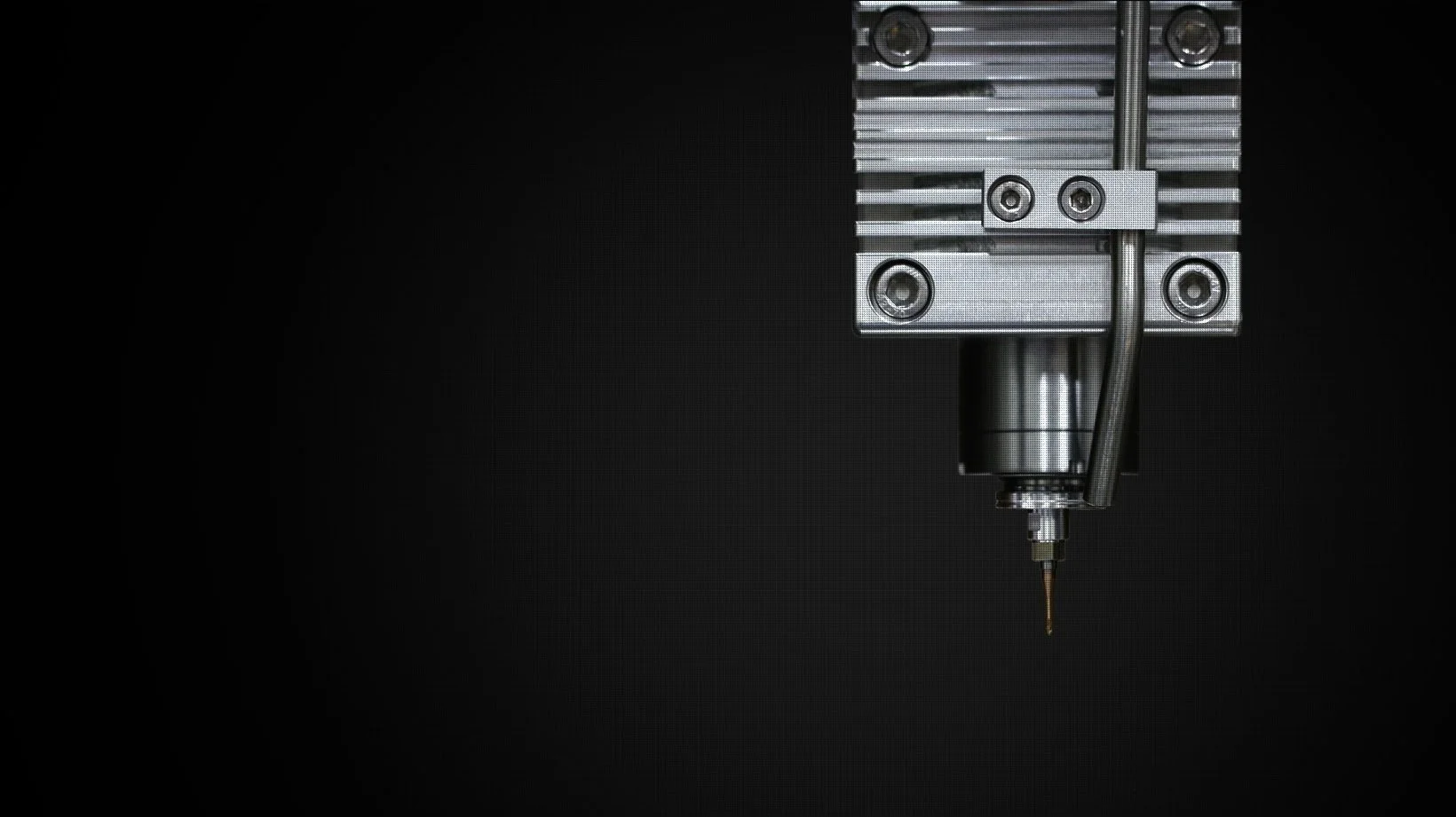 Nahaufnahme einer CNC-Fräse mit Bohrer auf schwarzem Hintergrund.