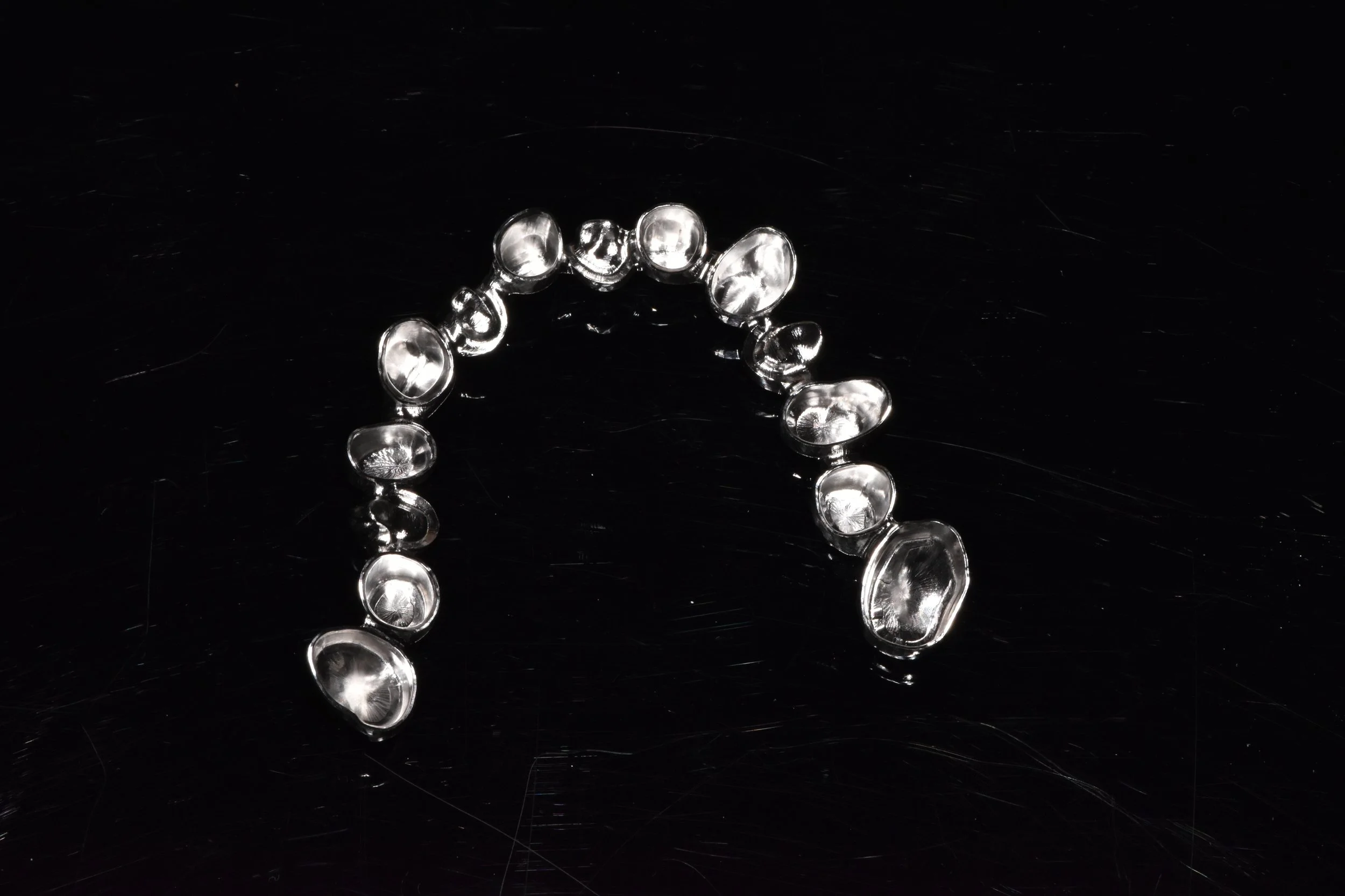 Silberne Halskette mit ovalen Gliedern auf schwarzem Hintergrund