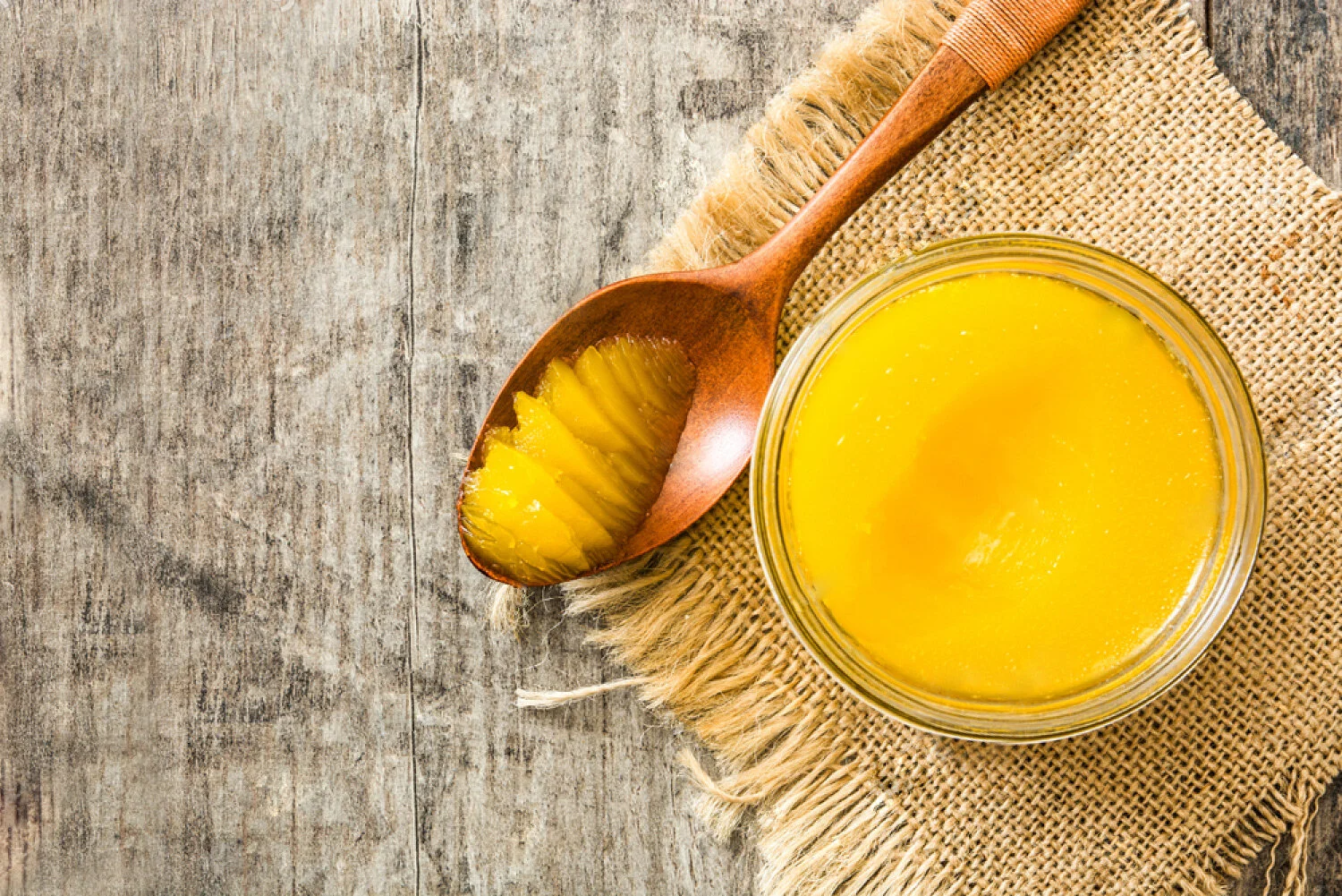 stock-photo-ghee-or-clarified-butter-in-jar-and-wooden-spoon-on-wooden-table-top-view-copyspace-1115979773.jpg