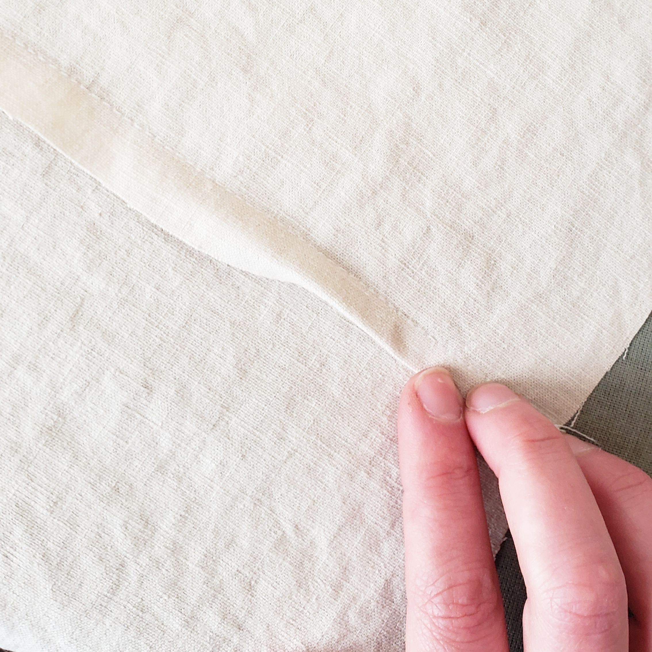 3. Lay the fold down, concealing the raw edges and exposing the original seam line