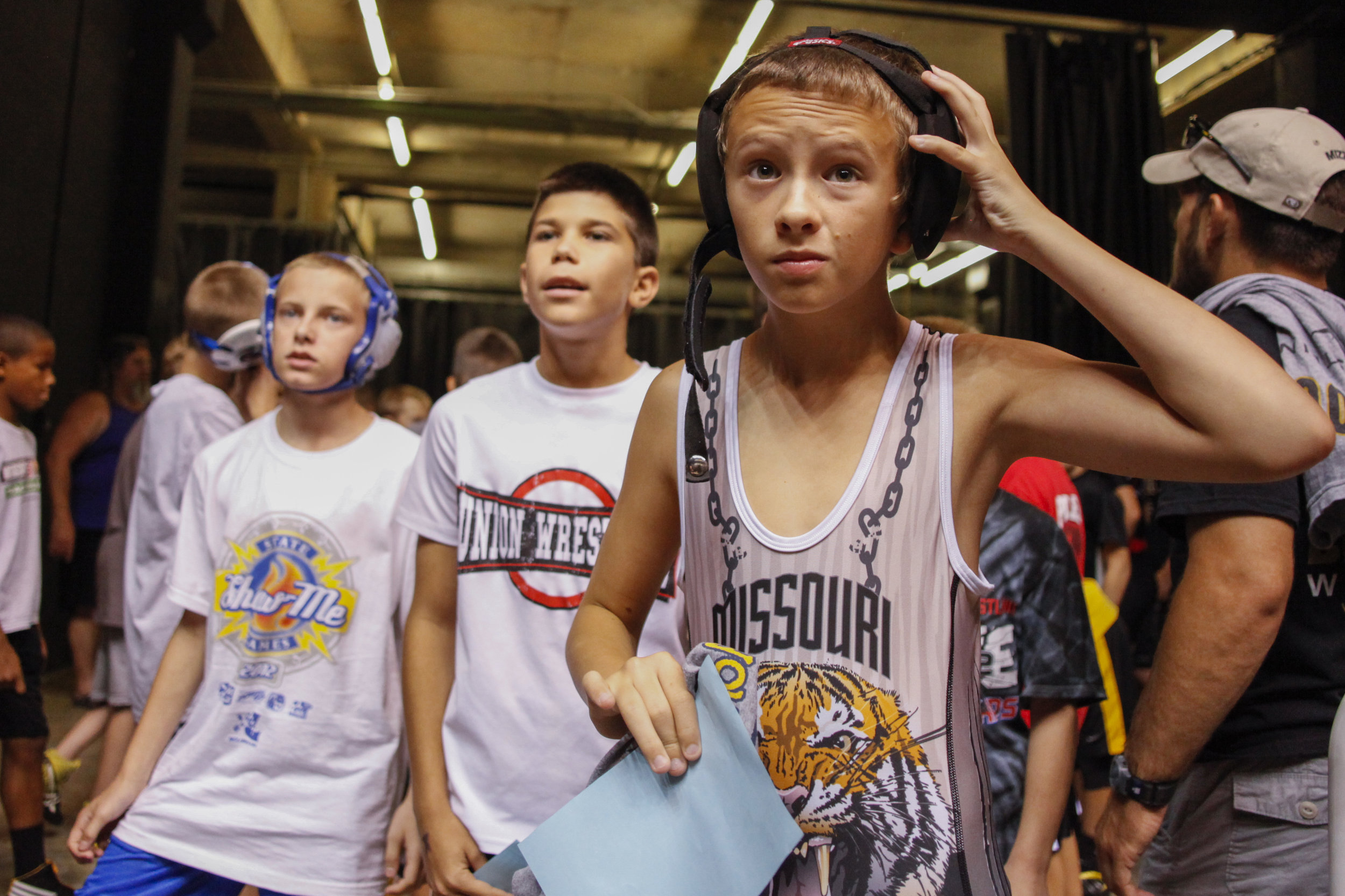  12-year-old Jake Justice, right, puts his gear on before he steps onto the mat for his first match of the day Saturday morning at the Show -Me State Games at the Hearnes Center. Jake has been wrestling since he was 7.     