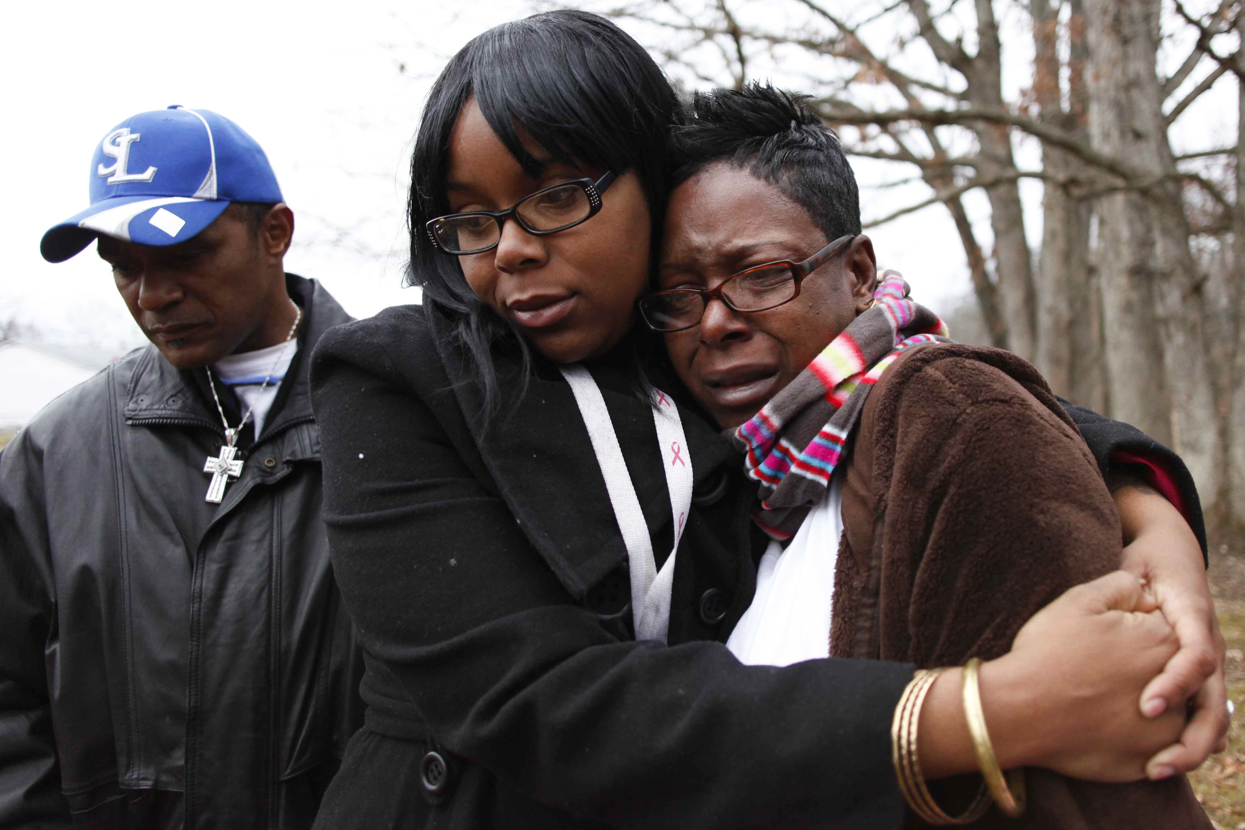  Taquaisha Nelson, center, hugs her mother Trinia Nelson, right, as they visit the grave of brother and son, Tevin Nelson, Monday, Dec. 26, 2011 at Log Providence Cemetery. Tevin's father, Keith Holmes, left, looks on his son’s grave as well.     