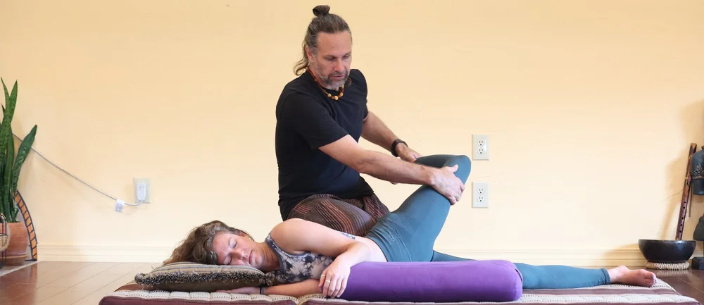 Andrew Eppler opening a hip with slow pressure during a Thai massage session