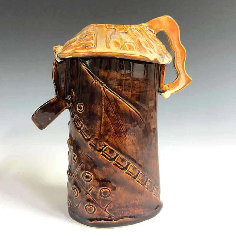 Brown textured vase with golden red top