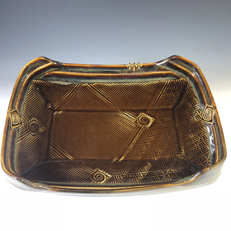 Rich tones of brown and jasper grace this large serving platter