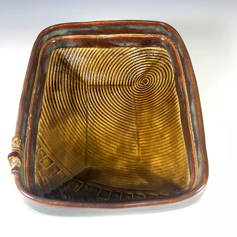 Artful golden brown footed serving platter with hints of misty blue