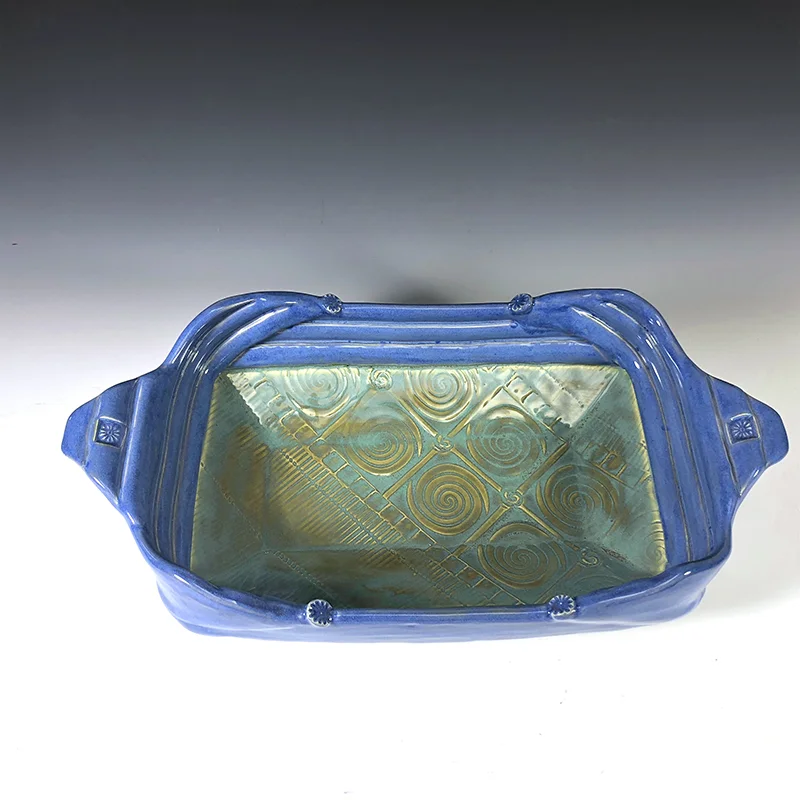This footed platter of golden turquoises and frosty blues will be a great addition to your table