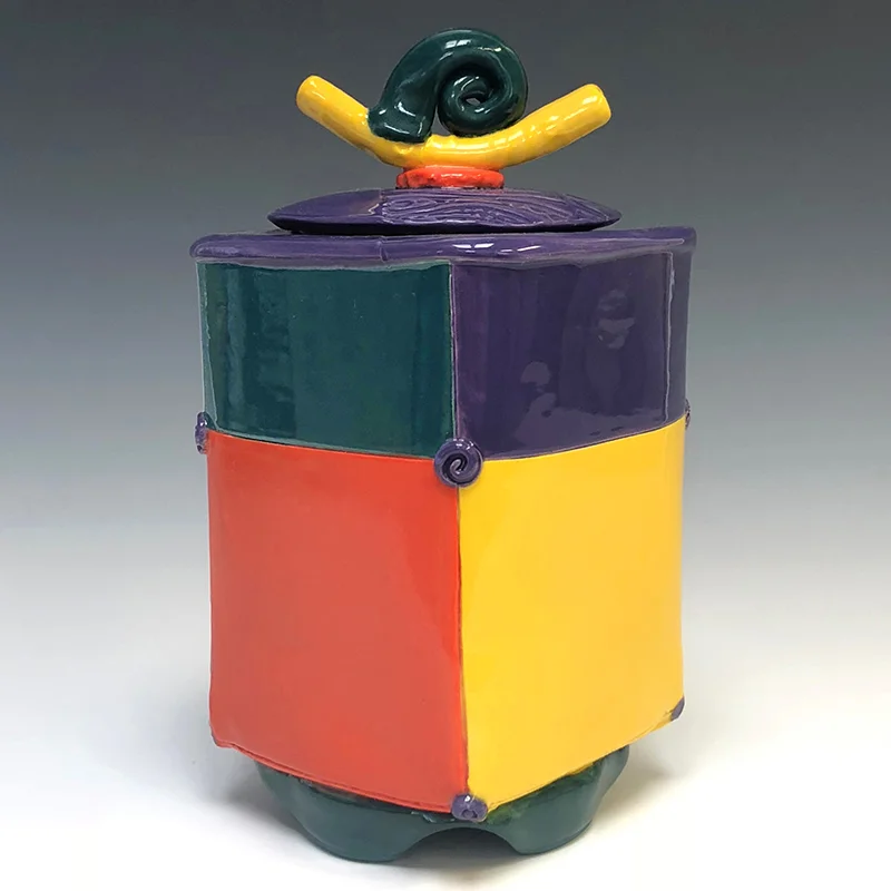 Vivid colors and an exultant spiral adorn this footed treasure container
