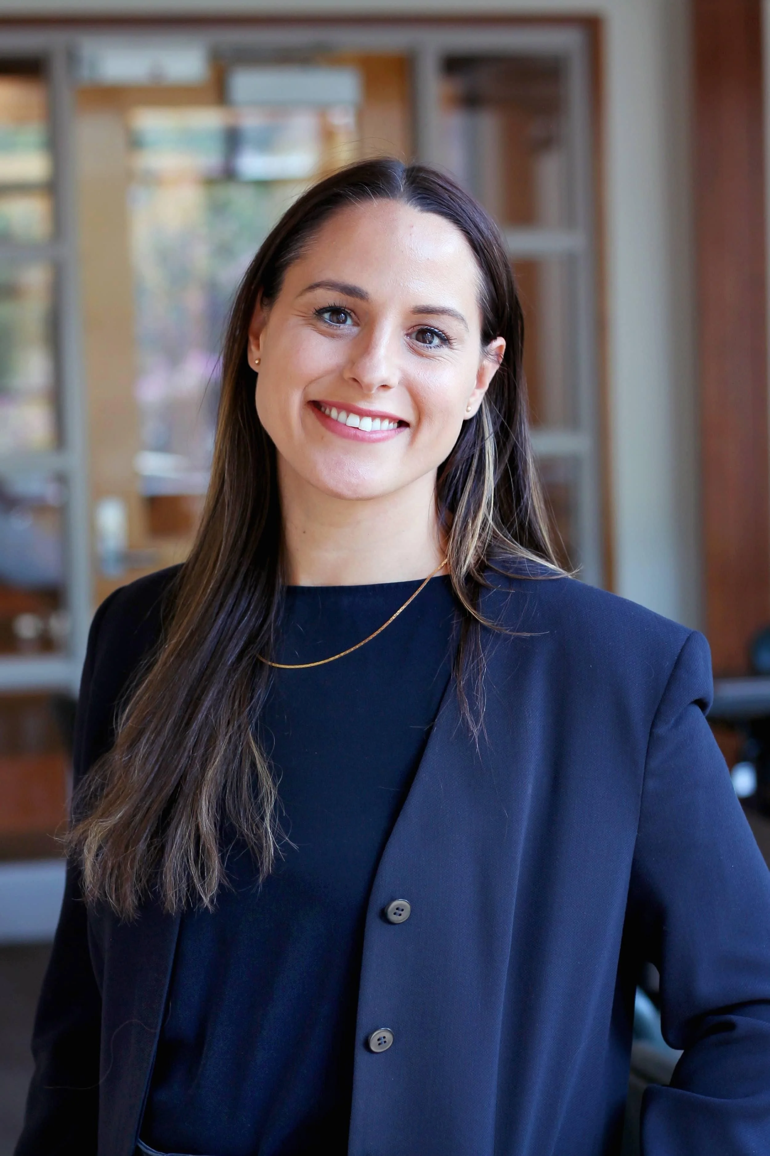Portrait of Robyn Caplan wearing a blue suit