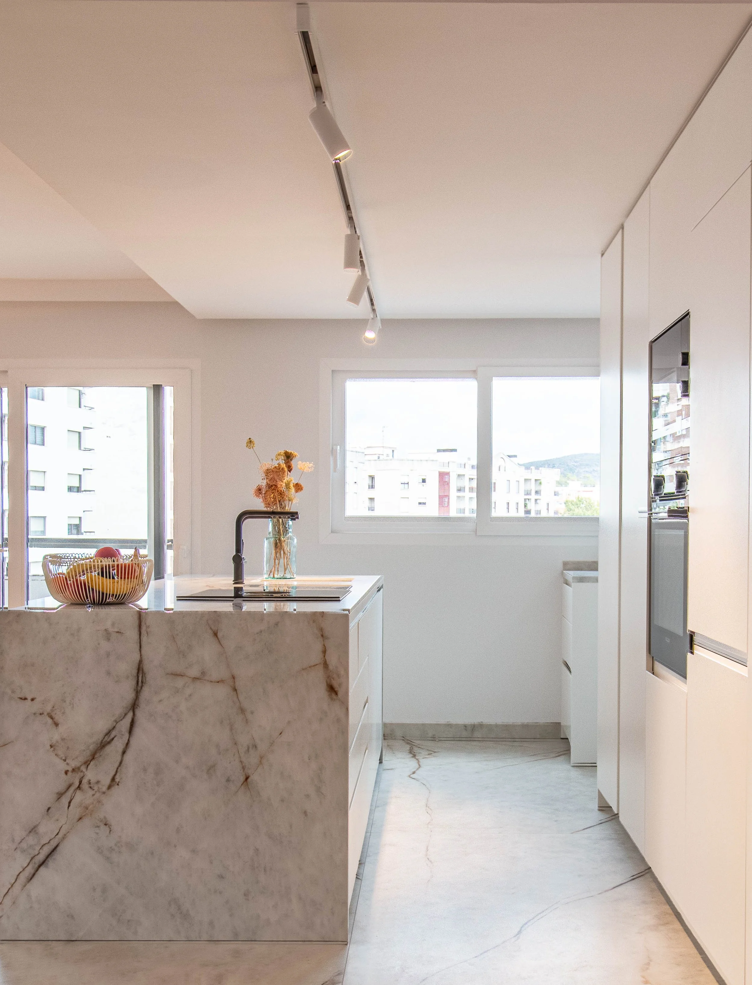 Cocina con isla de mármol en reforma integral de ático en el centro de Gandia (Valencia) – Betha Estudio