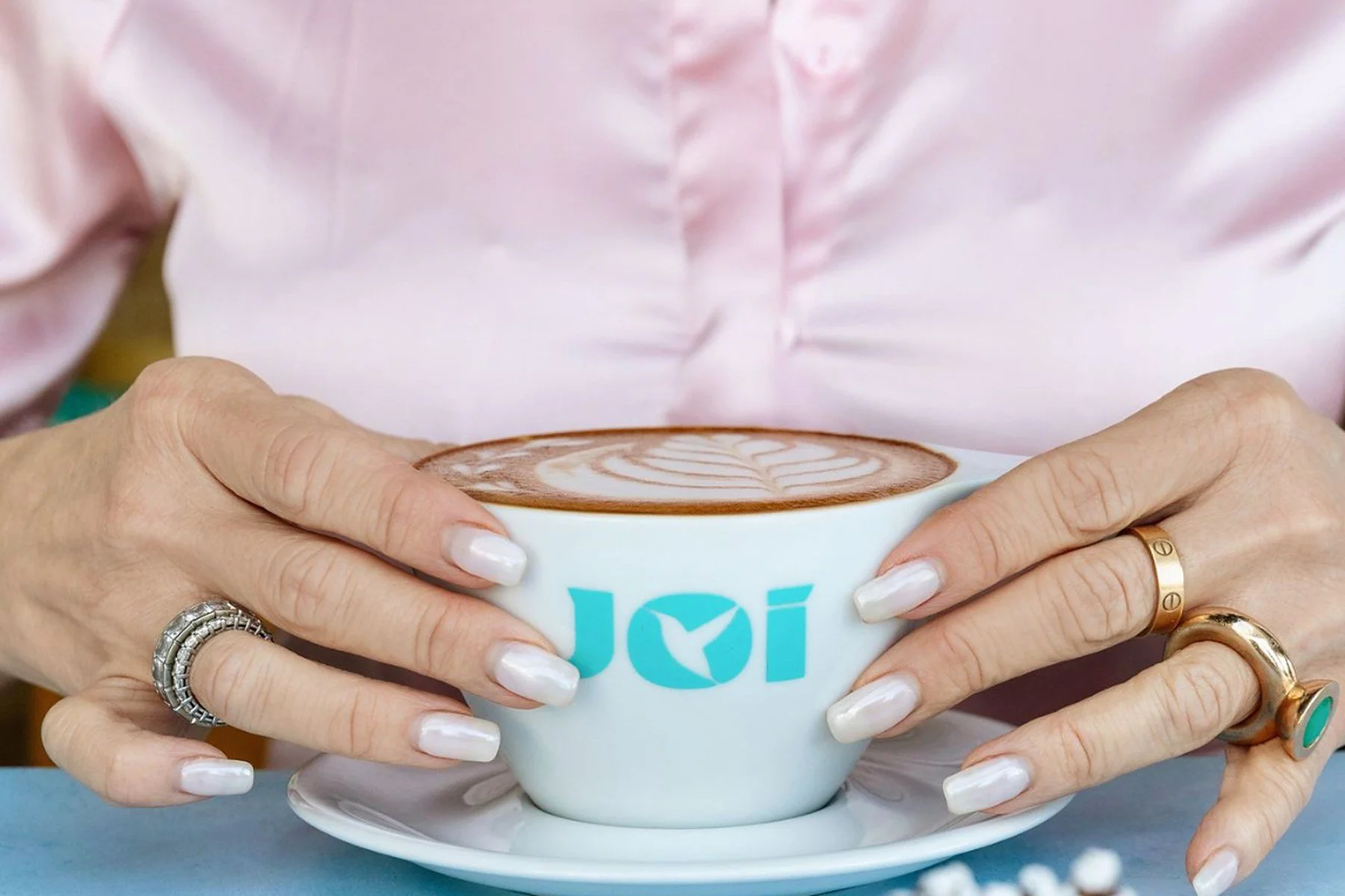 A latte in a JOi Café cup with fruit-topped toast