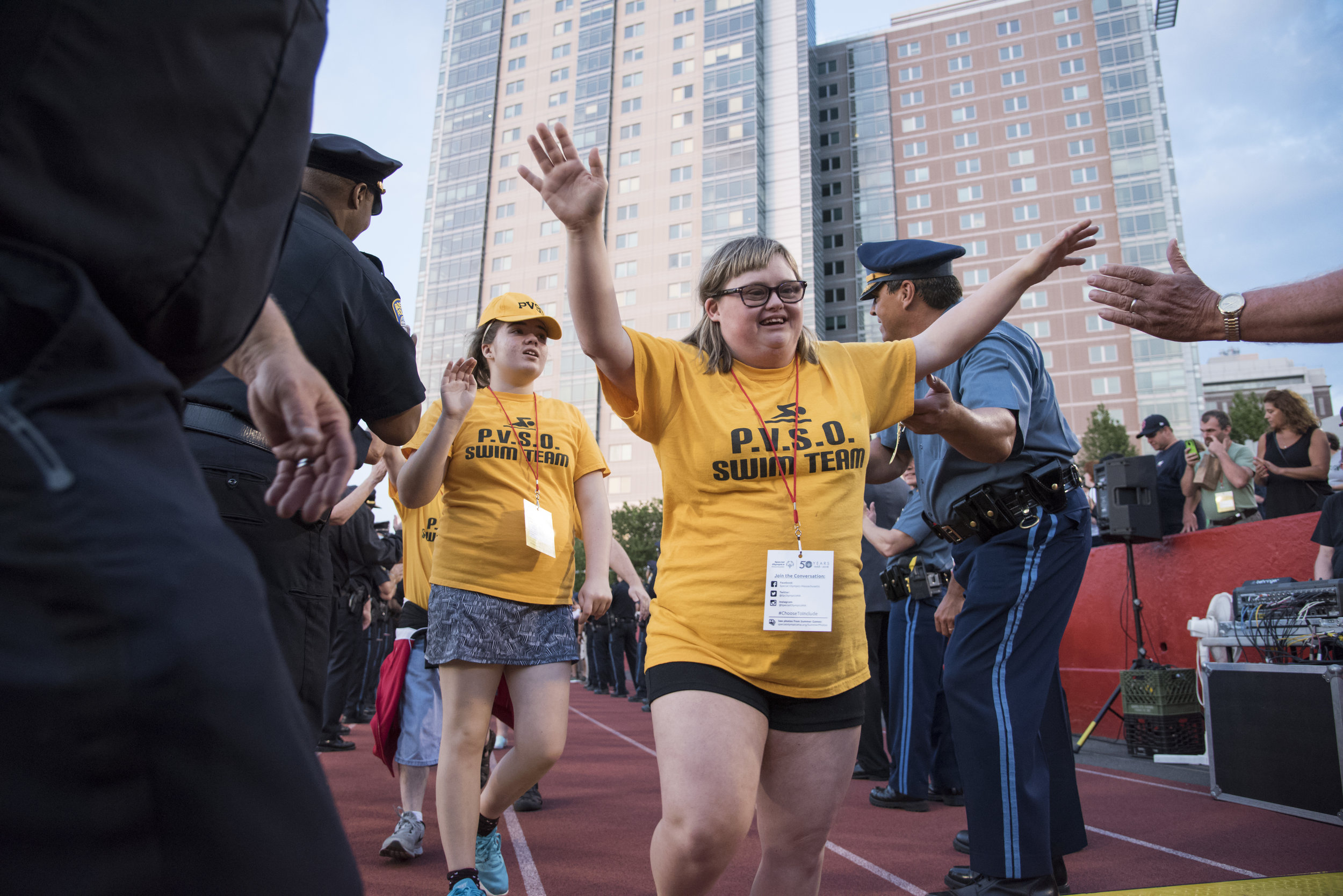  Kayla Edgar, a Special Olympics athlete with the Pioneer Valley Aquatics Program, high-fives Boston police officers during the Parade of Athletes, a part of the 2018 Summer Games opening ceremony held on Boston University's Nickerson Field. This yea