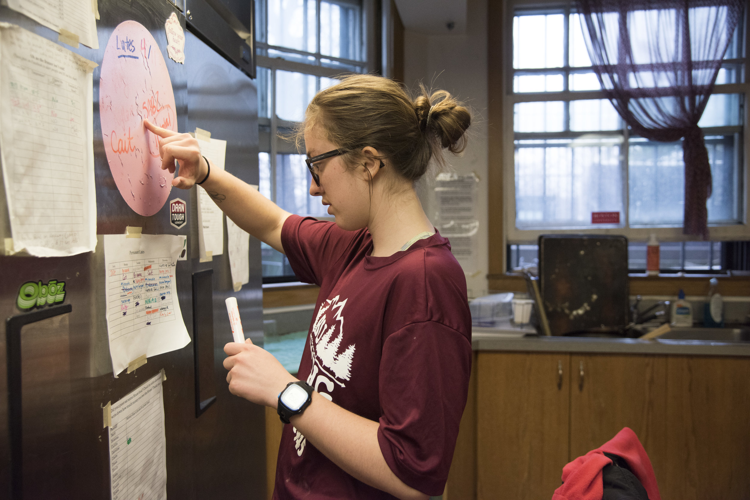  Rachel Poppe, a senior at Boston University, consults the list of late arrivals as she prepares to make dinner for her housemates at the Harriet E. Richards--or HER--house, a women's cooperative residence hall at Boston University. Members of the ho