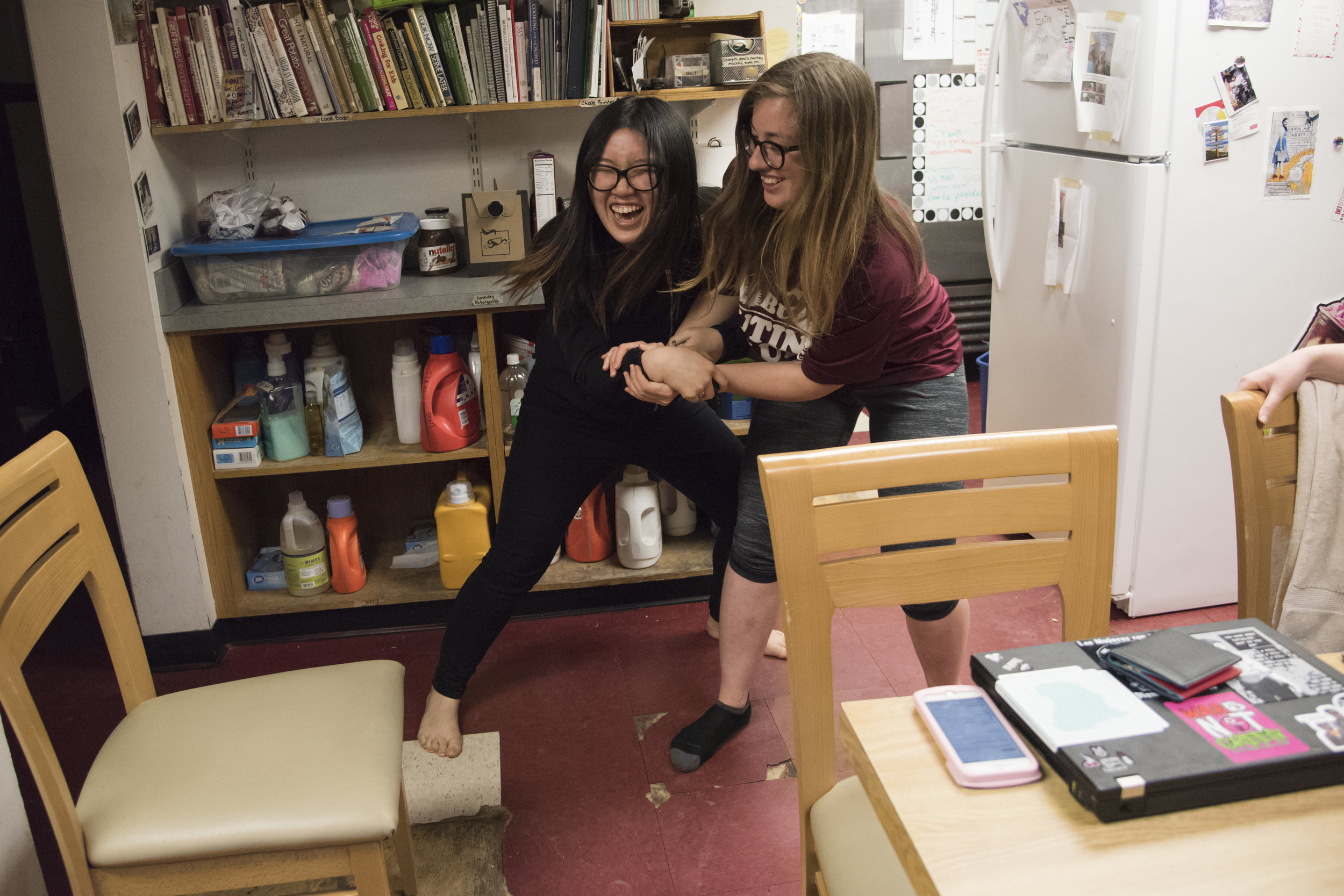  Ningyin Zhao and Rachel Poppe, both juniors at Boston University and both members of the Kung Fu team, demonstrate their moves in the HER House kitchen before leaving for practice. 