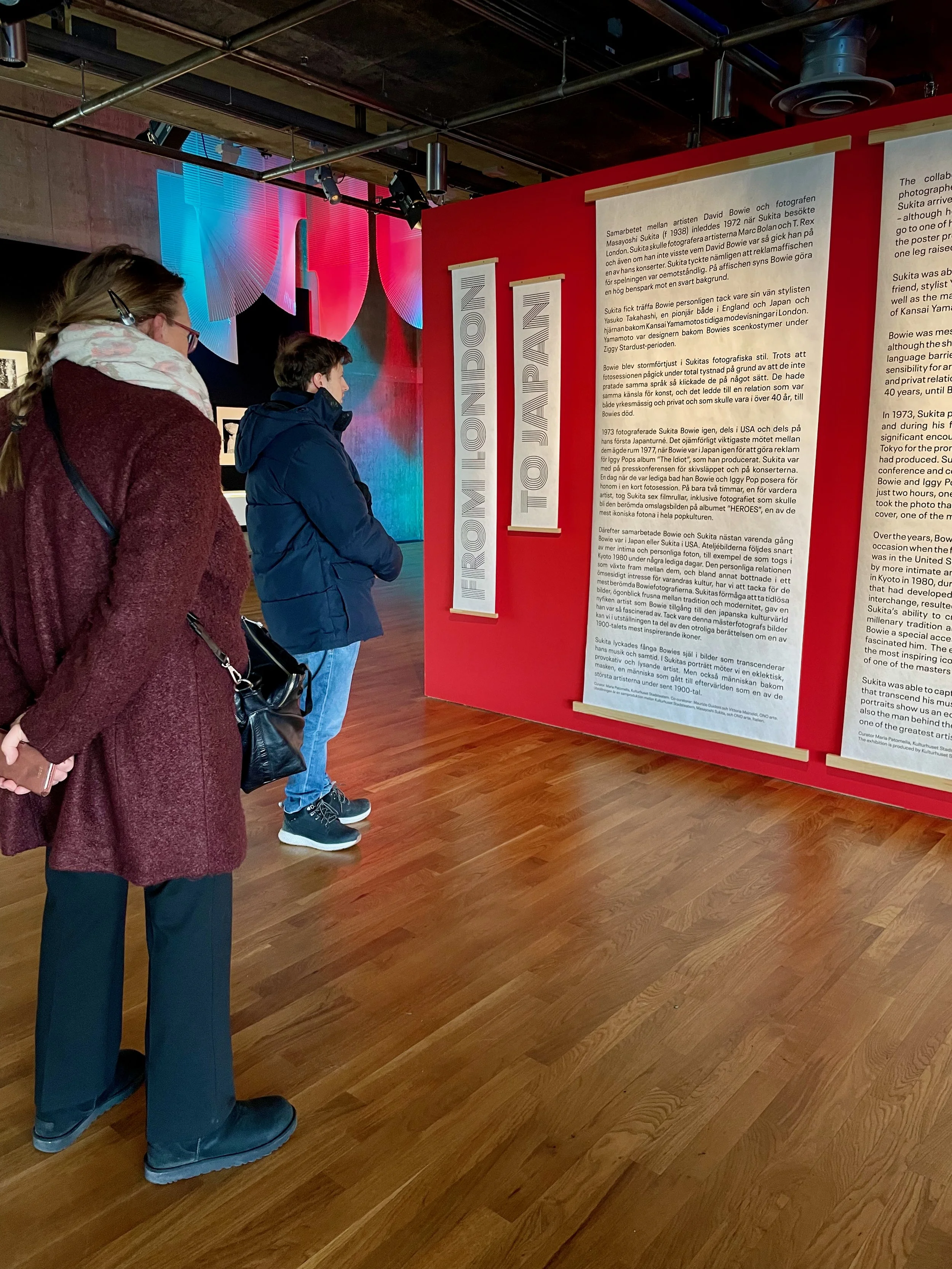 Två personer läser text i en utstsällning om David Bowie.