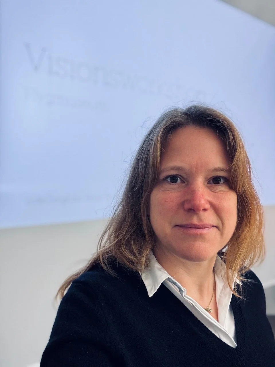 Sofie Bergkvist står framför en skärmpresentation i ett mötesrum