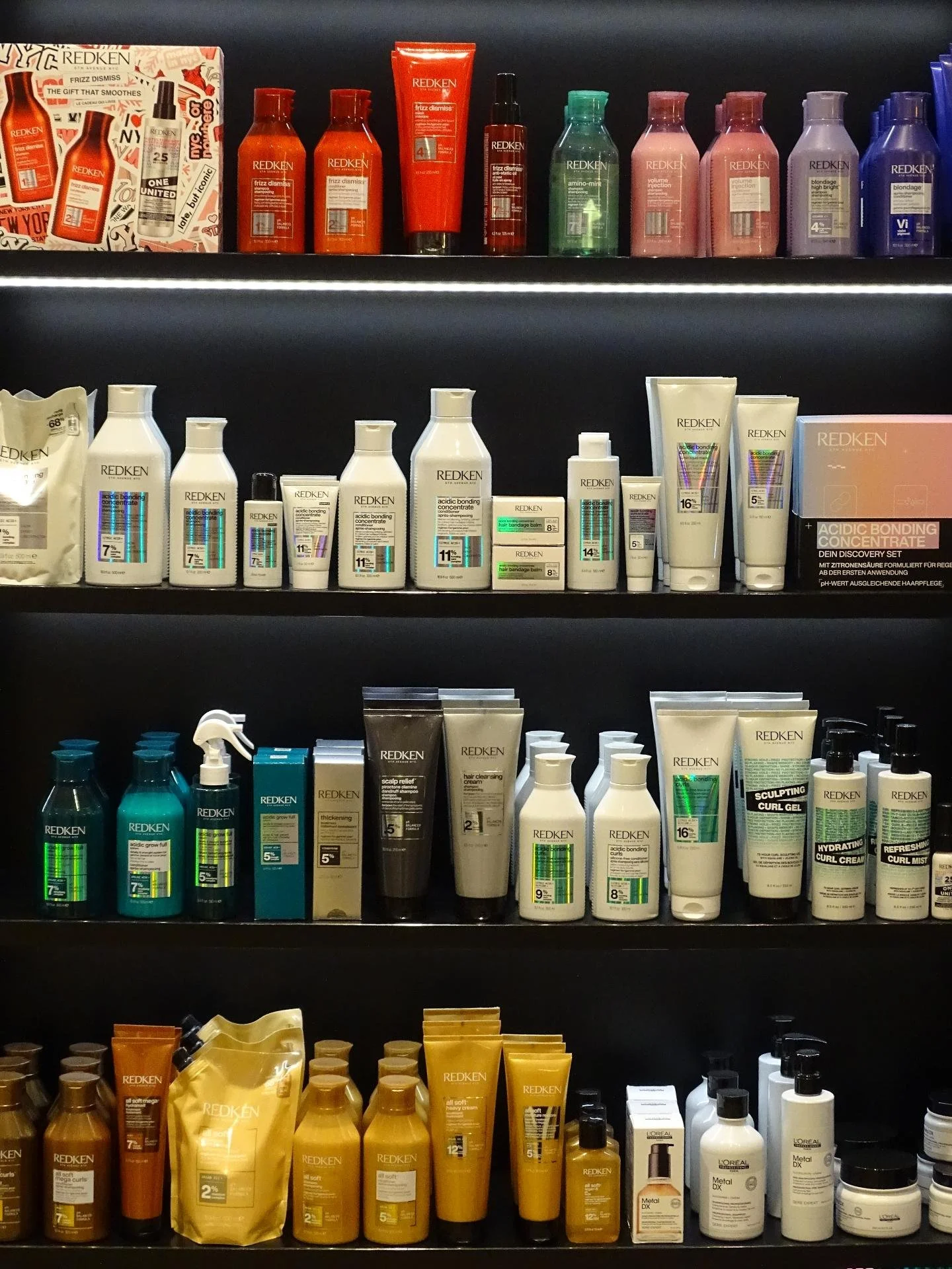 Redken Haarpflege- und Stylingprodukte im Regal im Salon Haarscharf auf Fehmarn