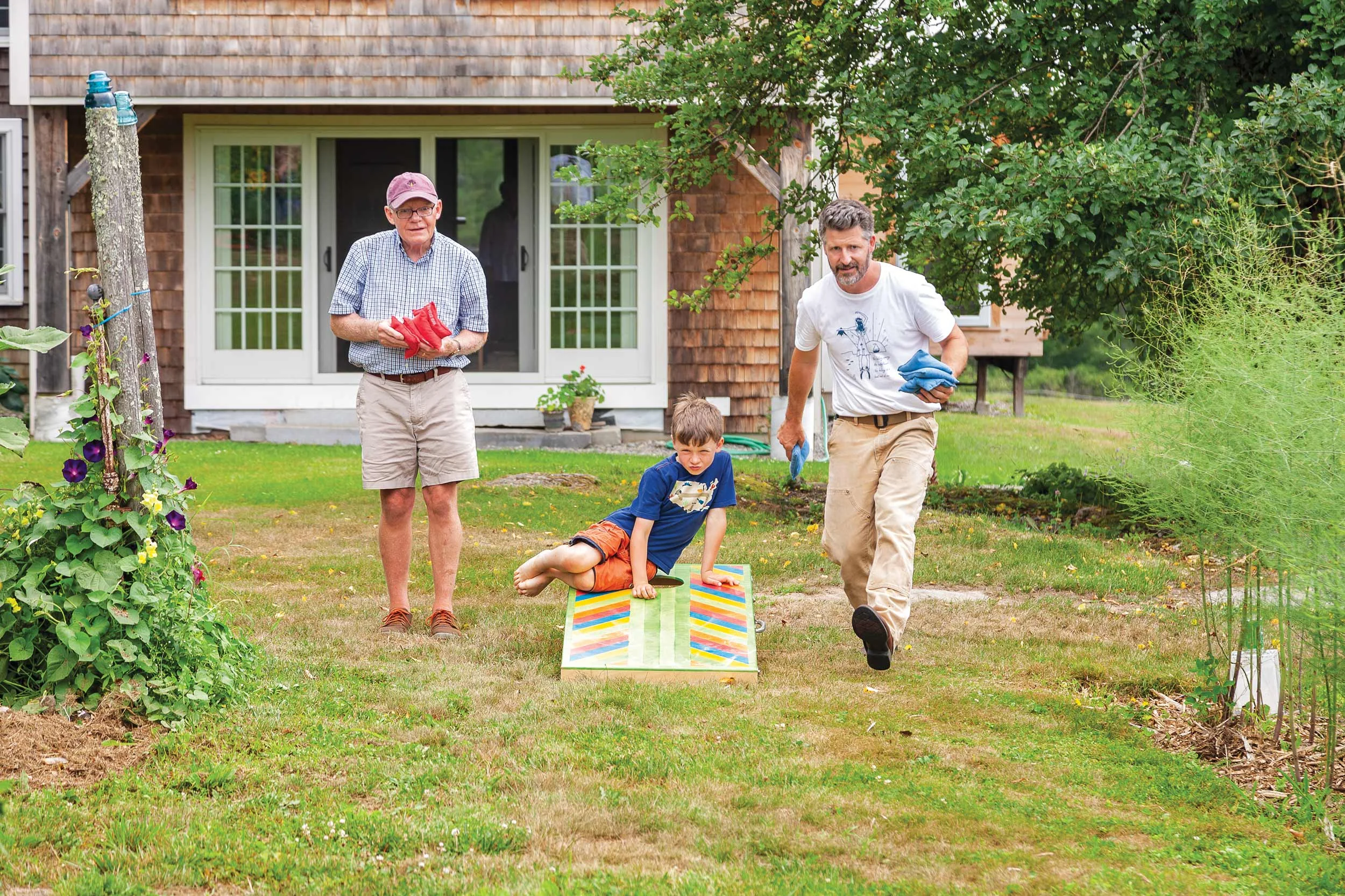 Three generations of Manahan men try their hand at Cornhole on boards hand made by Josh.
