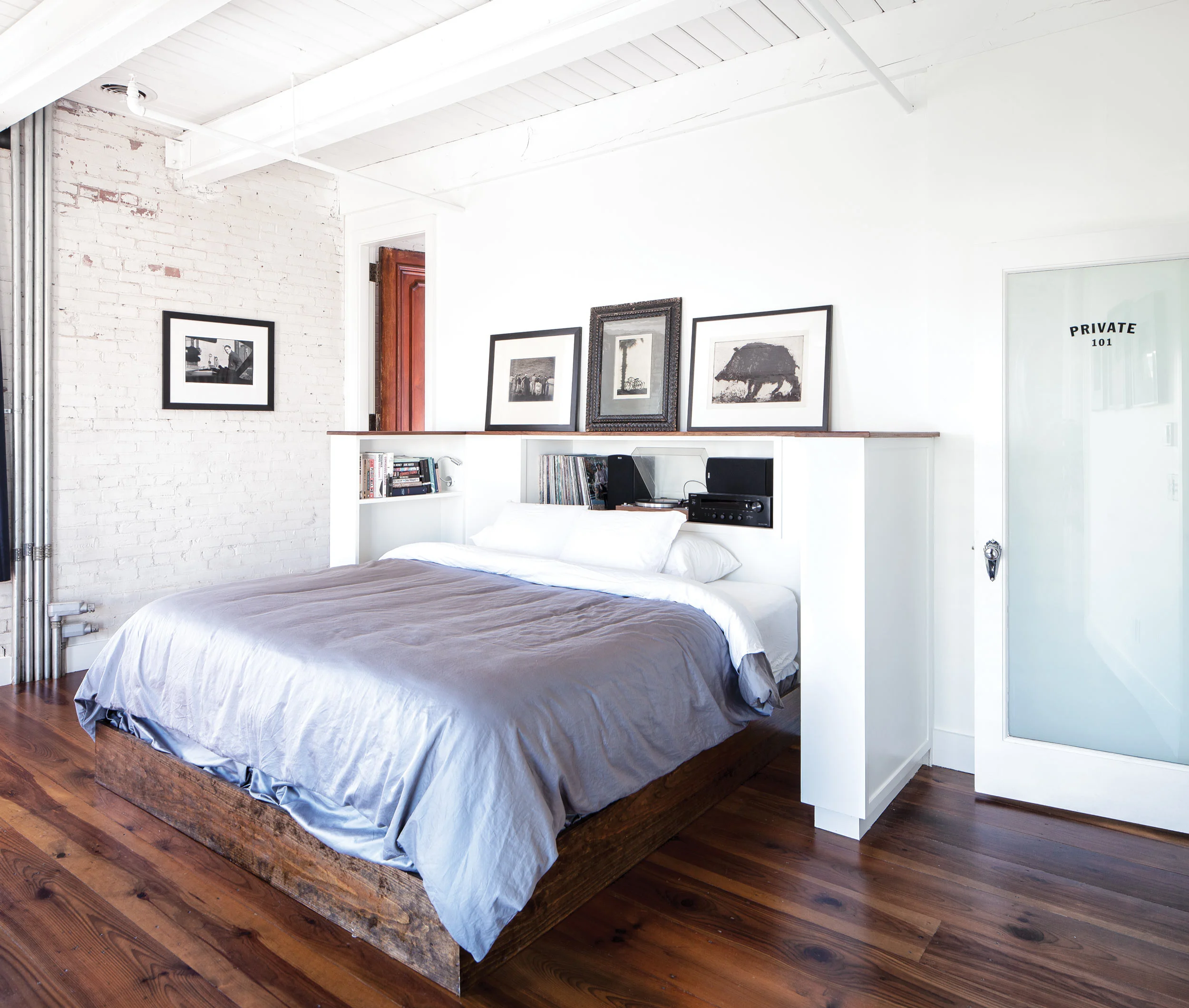 Keon told cabinetmaker Paul Lewin that he wanted to listen to music in bed, so Lewin built this bed nook to house his stereo and serve as a record cabinet while also displaying art like the etching of a pig by Tom Cornell and a 1923 William H. Bettle silver gelatin print of a luxury liner.