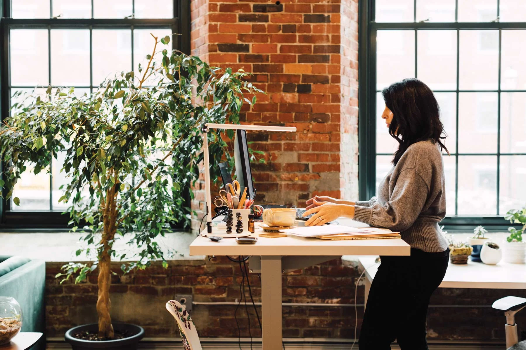 Zoulamis, at her desk, which enjoys a view and the company of many plants.