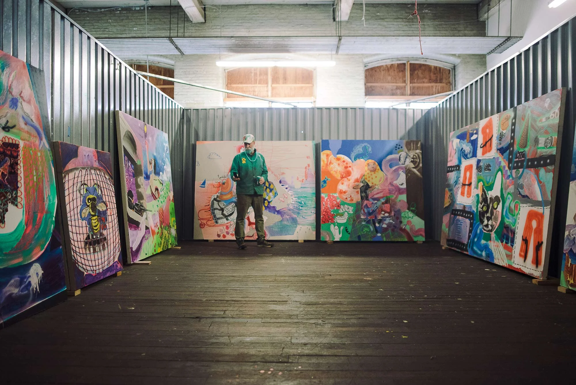 Many of our state’s finest artists create in the Fort Andross Mill—here, sculptor John Bisbee among Emilie Stark-Menneg’s paintings.