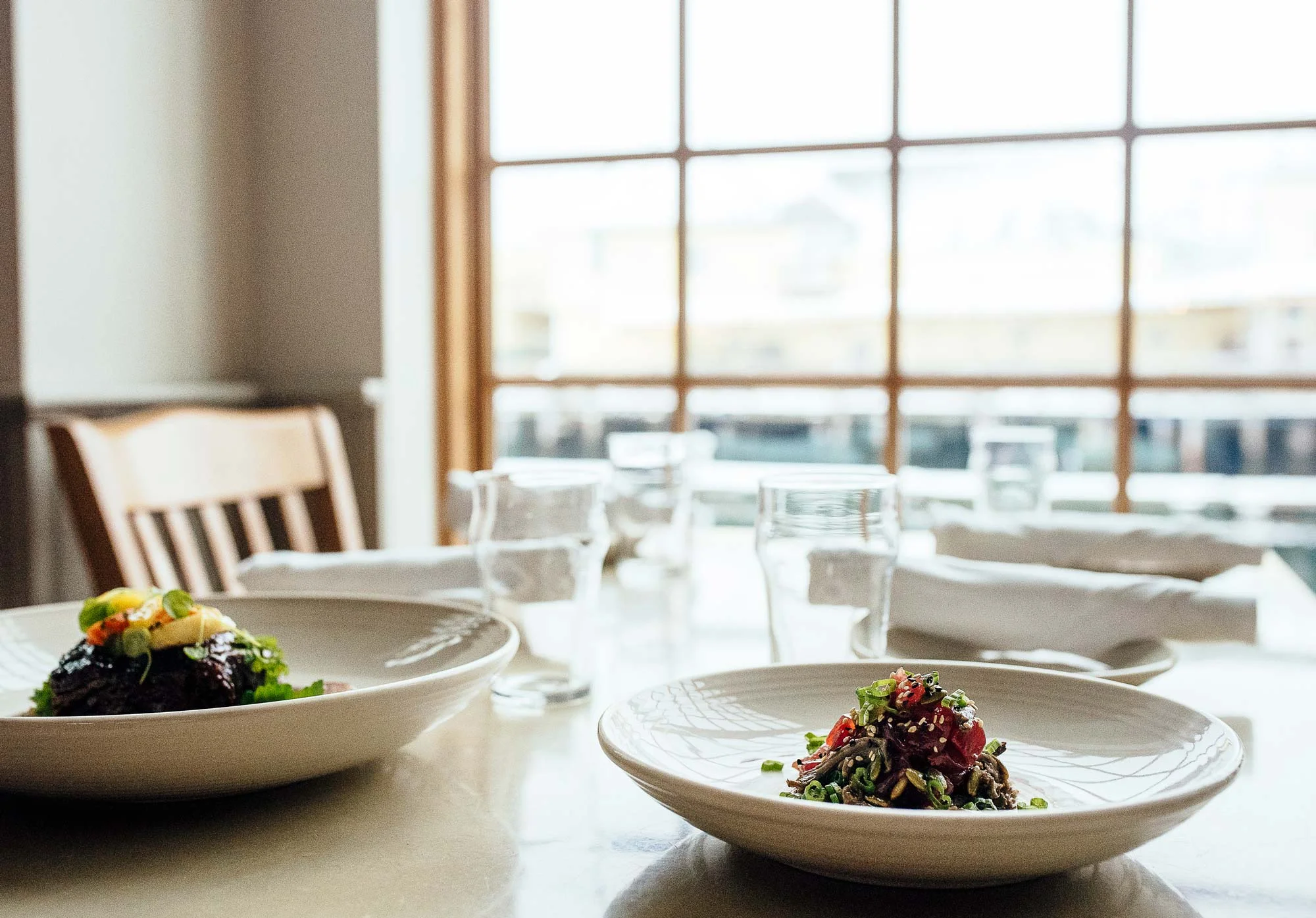 The views through the massive windowpanes serve as a reminder that one is, in fact, dining while suspended over the waterfront.