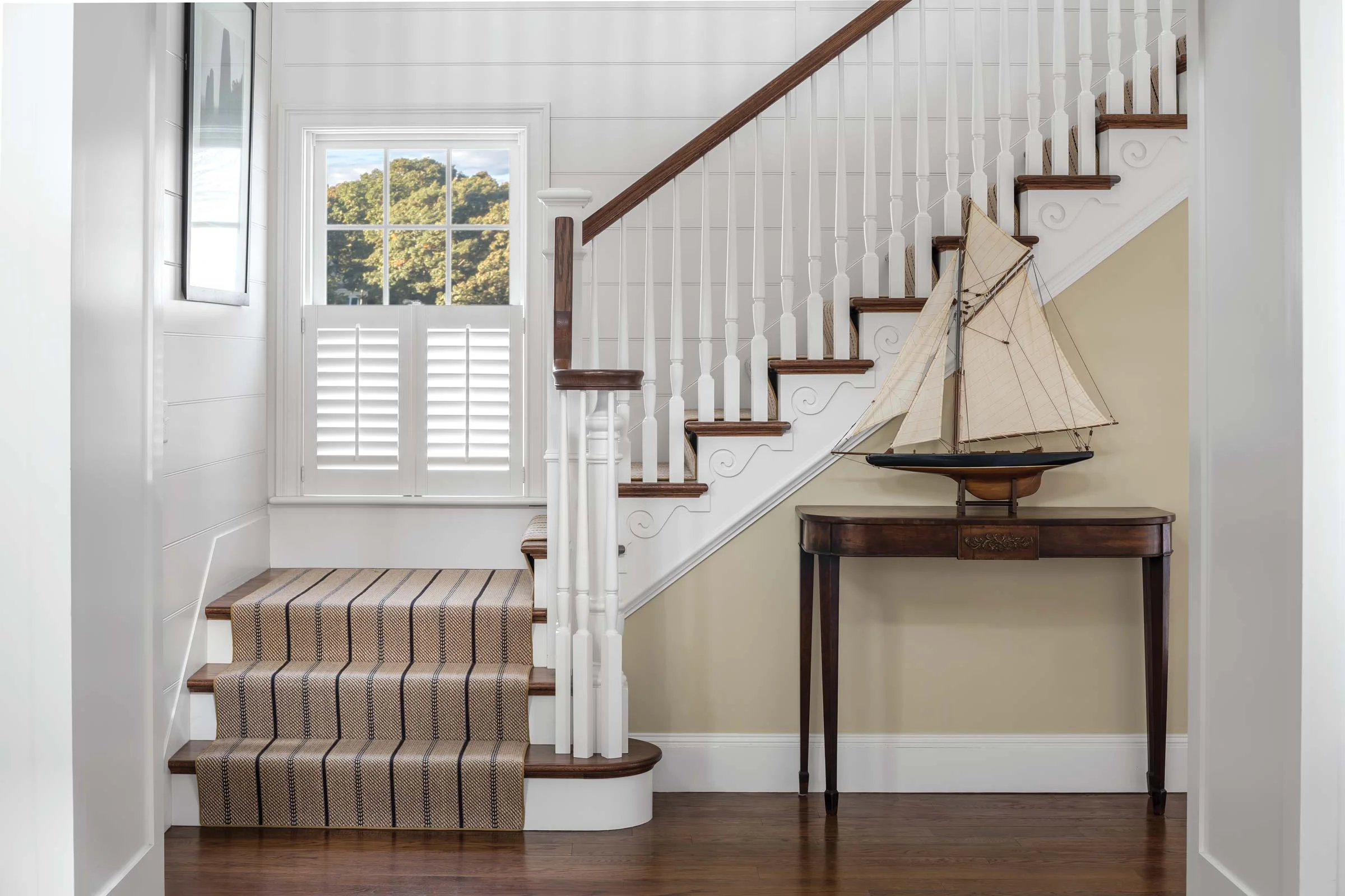 The KA schooner model displayed in the hall interplays with the undulant wave-like molding that runs along the staircase crafted by Brian Sleeper of Period Restoration.