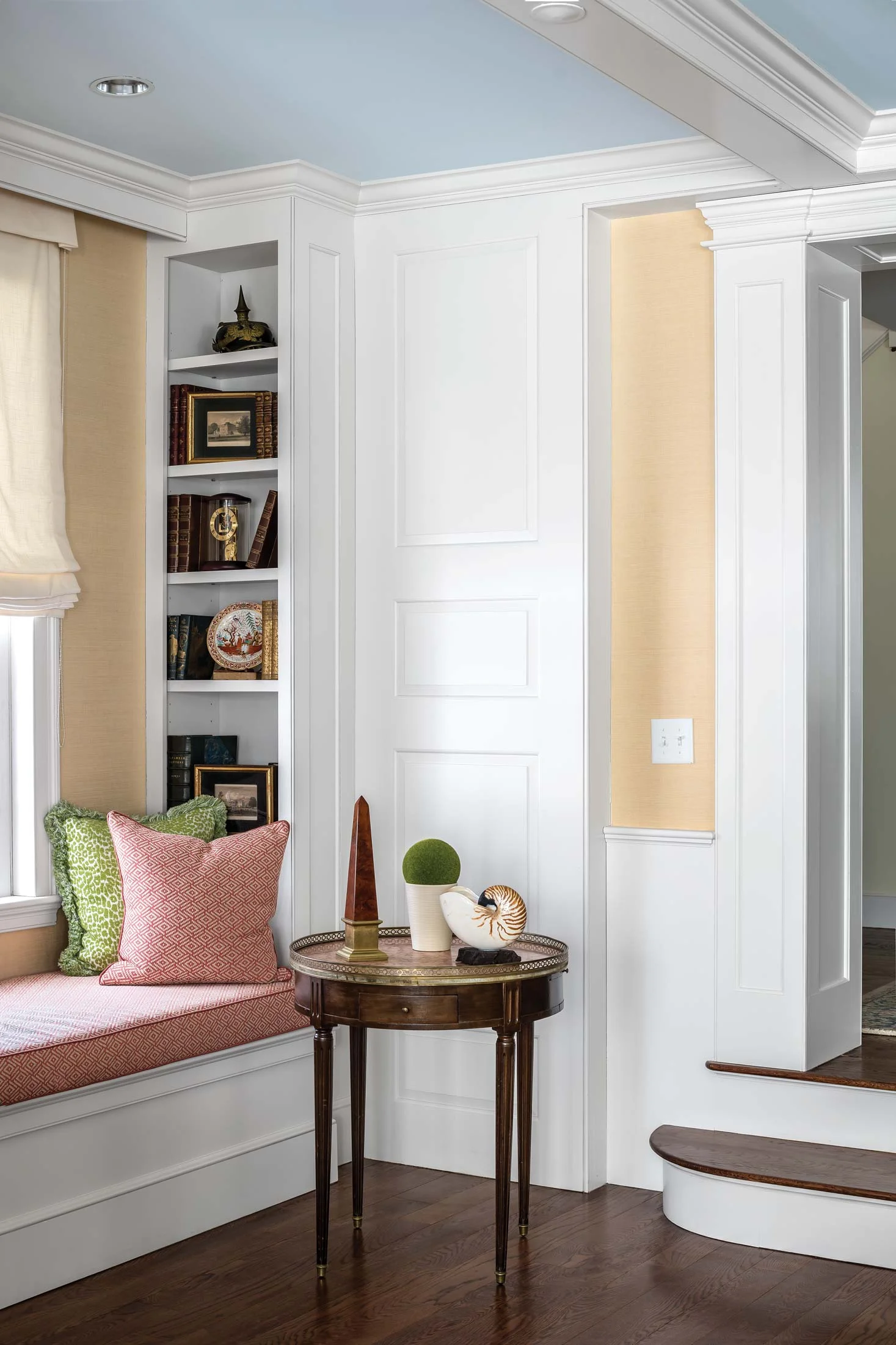 One of the many window seats in the home provides a cozy reading nook alongside built-in shelves for books and objets d’art.