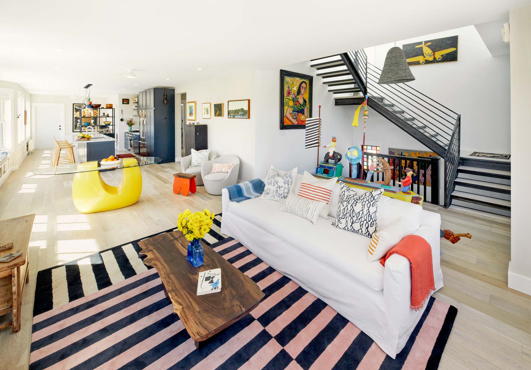 Soozie’s sleek living space is anchored by a graphic striped rug from HEM. In the background, a Victorian-era stained glass window original to the building complements the colors of Belfast , a painting by Philip Barter, and a portrait of a woman by Nance Parker.