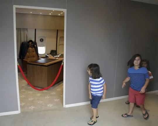 In this Monday, Sept. 18, 2017 photo Camden Palmisciano-Wright, 4, left, and Riley Palmisciano-Wright, 6, approach the president's office on board the "Air Force One Experience," a full-sized 747 replica of Air Force One which is now open to the public in North Kingstown, R.I. (AP Photo/Stephan Savoia)
