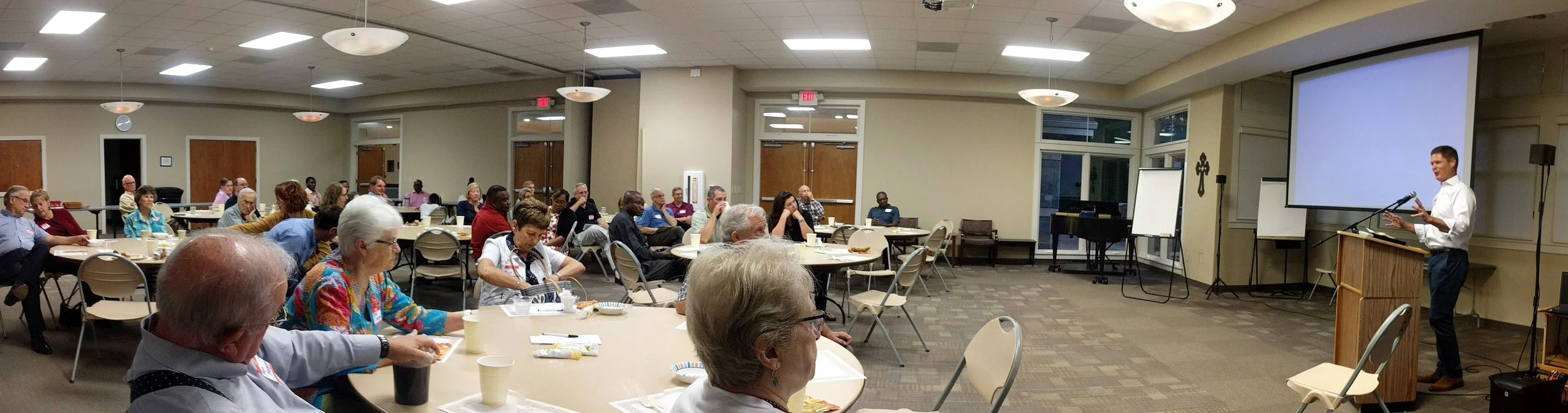 Philip Cope, President of the Board of Directors of OFCB Ministries, speaks to attendees at a dinner supporting the Bridges of Bayonnais project.