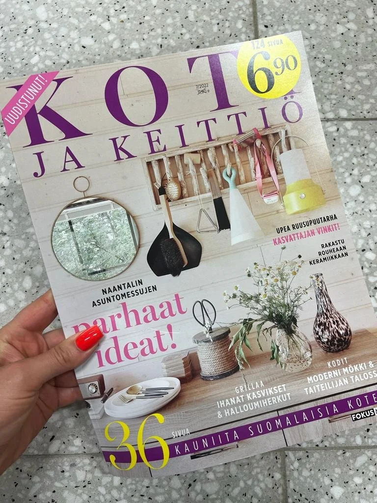 Kotiloa ja Keittiö -lehden kansi, jossa näkyy keittiön esineitä roikkumassa seinällä, pyöreä peili ja pöydällä maljakko sekä muita koriste-esineitä. Kannessa tekstit liittyvät asumiseen ja ruoanlaittoon.