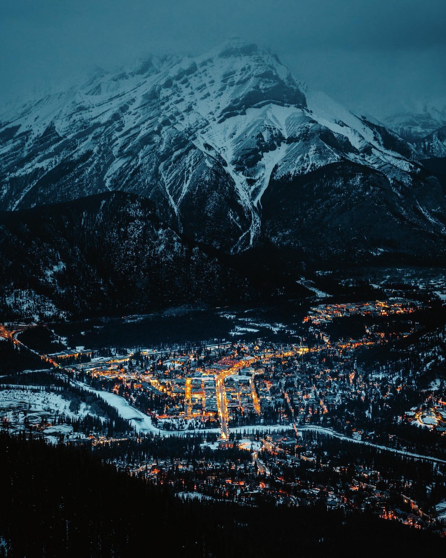 Banff Avenue lit up, leading you to Cascade Mountain ✨ one of the best views of the city is from the top of the Banff Gondola.⁣
⁣
📸: @sonyalpha a7S III + 24-70mm f/2.8 #alphacollective