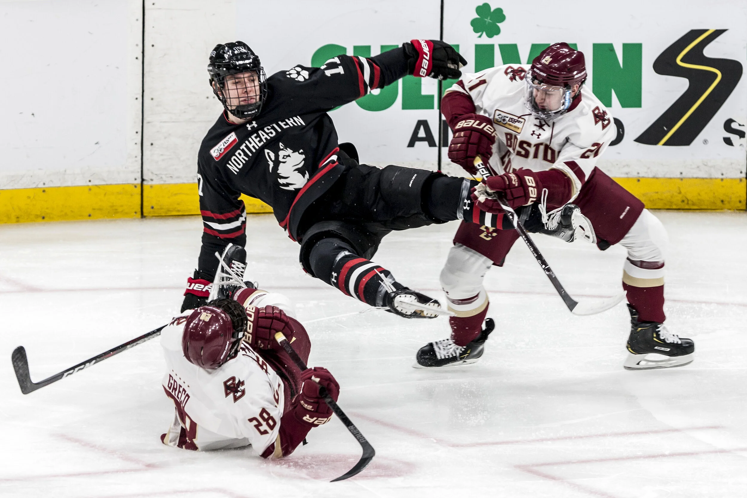  Austin Goldstein, of Northeastern University Men’s Hockey, is caught mid-air between two Boston College defenders during the 2019 Beanpot Final at TD Garden in Boston, MA. 