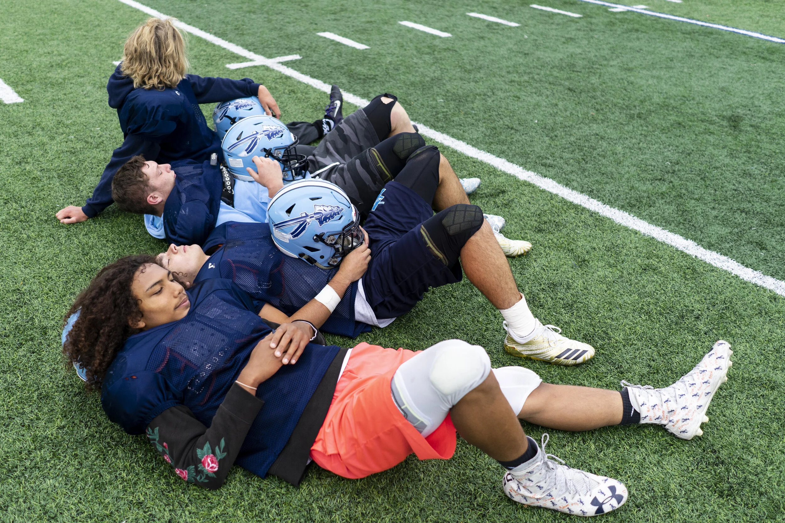  Members of the Indian River Varsity football team take a breather during a hard final practice before their big game against the Carthage Comets the following weekend.  