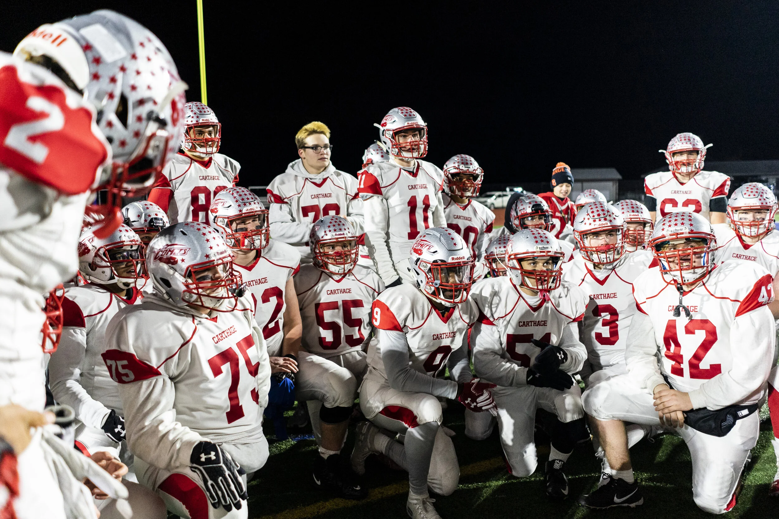  Carthage football players smile as they listen to Head Coach Jason Coffman deliver the victory speech after they defeated Canandigua Academy in Cicero, N.Y. on November 23, 2019. 