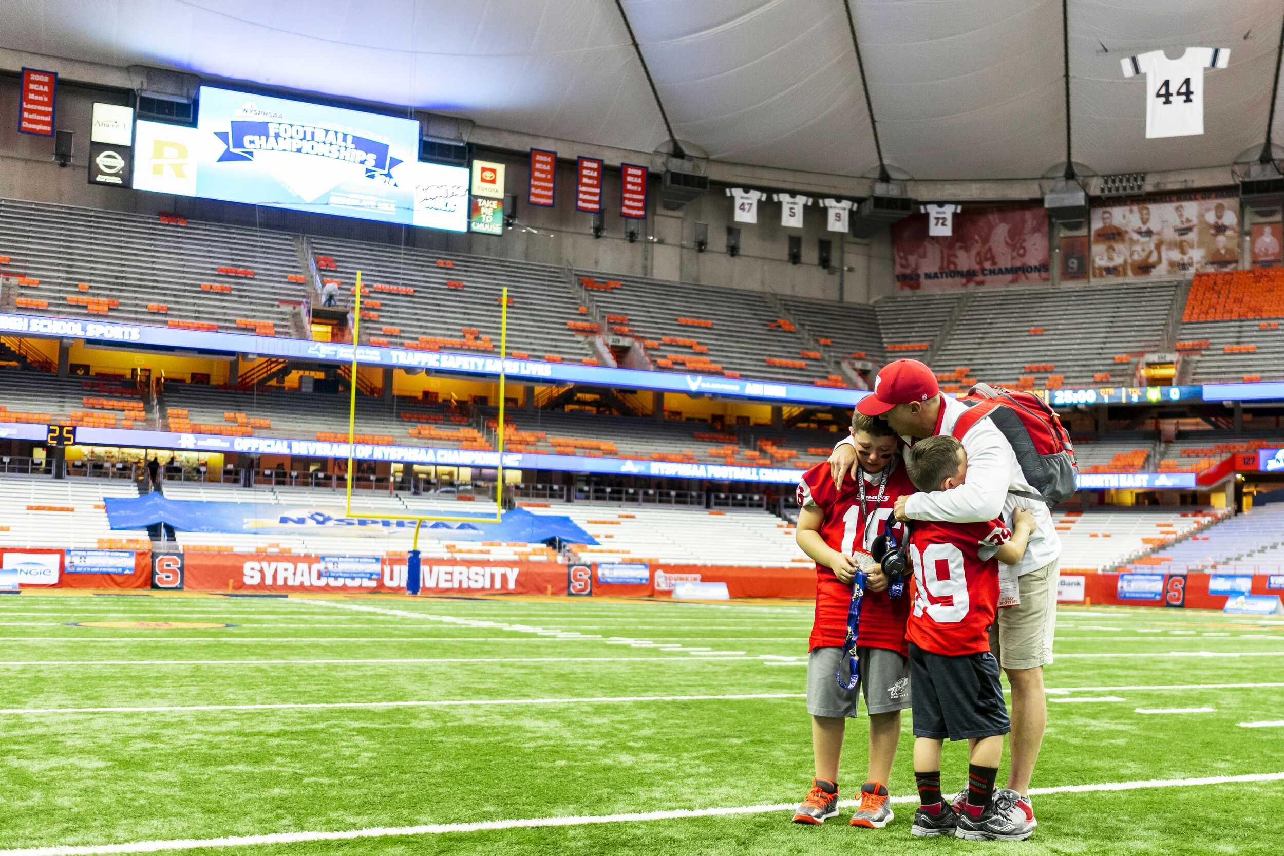  Two of the Carthage ball boys embrace a member of the coaching staff on the empty field after the devastating Carthage loss to Cornwall in the state championship final in Syracuse, NY. 