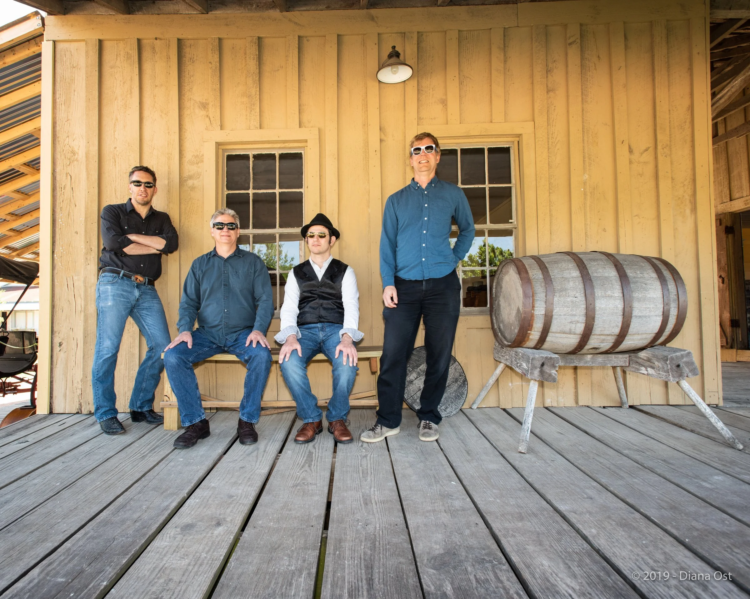Hot Pickin 57s posed on the porch of a historic wooden building at Pioneer Farms, Austin