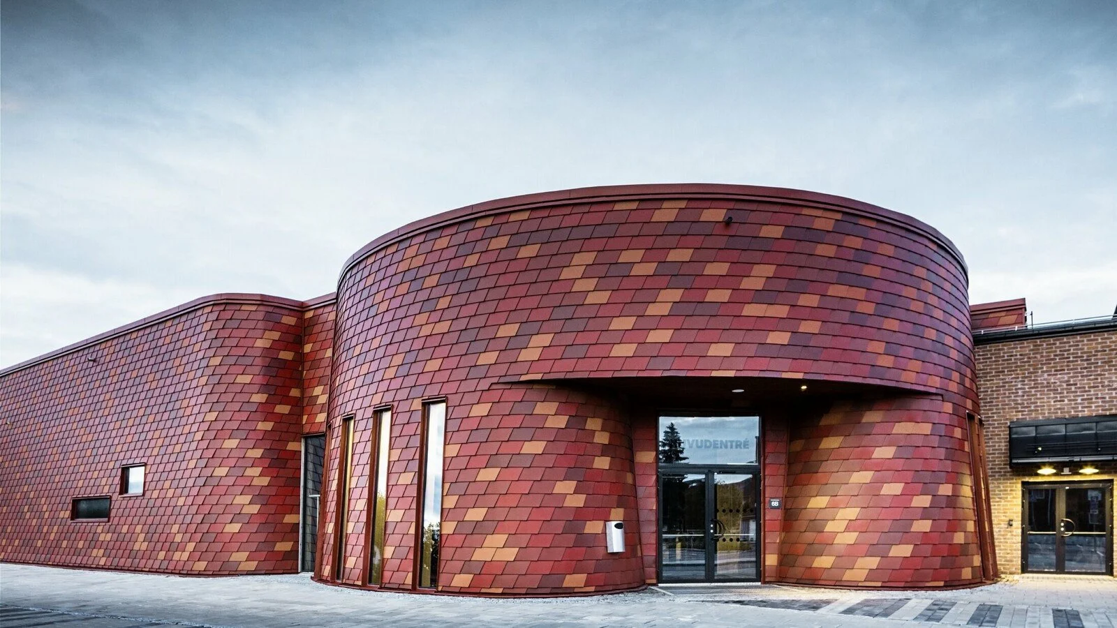 csm_PREFA-Gaellivare-Eventarena-Eishalle-Wandschindel-rottoene-oxydrot-ziegelrot-gerundete-Fassade-Eingang_565d800161.jpg
