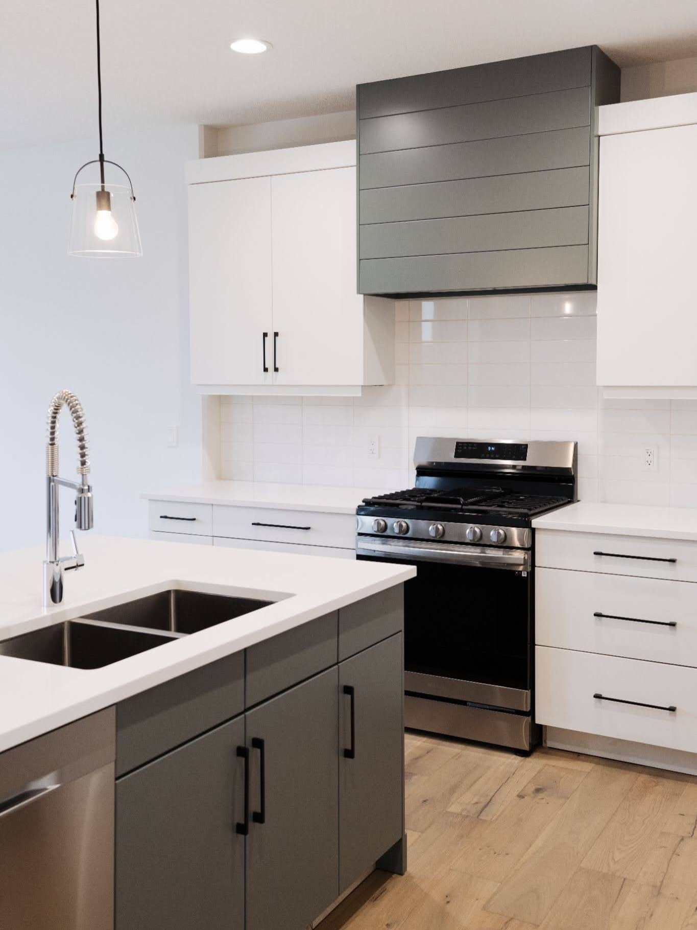 Swipe to see the crisp white countertops, custom cabinetry, and the must-have pantry that adds a whole new level of convenience to this kitchen. Designed to keep your main space bright and clutter-free.