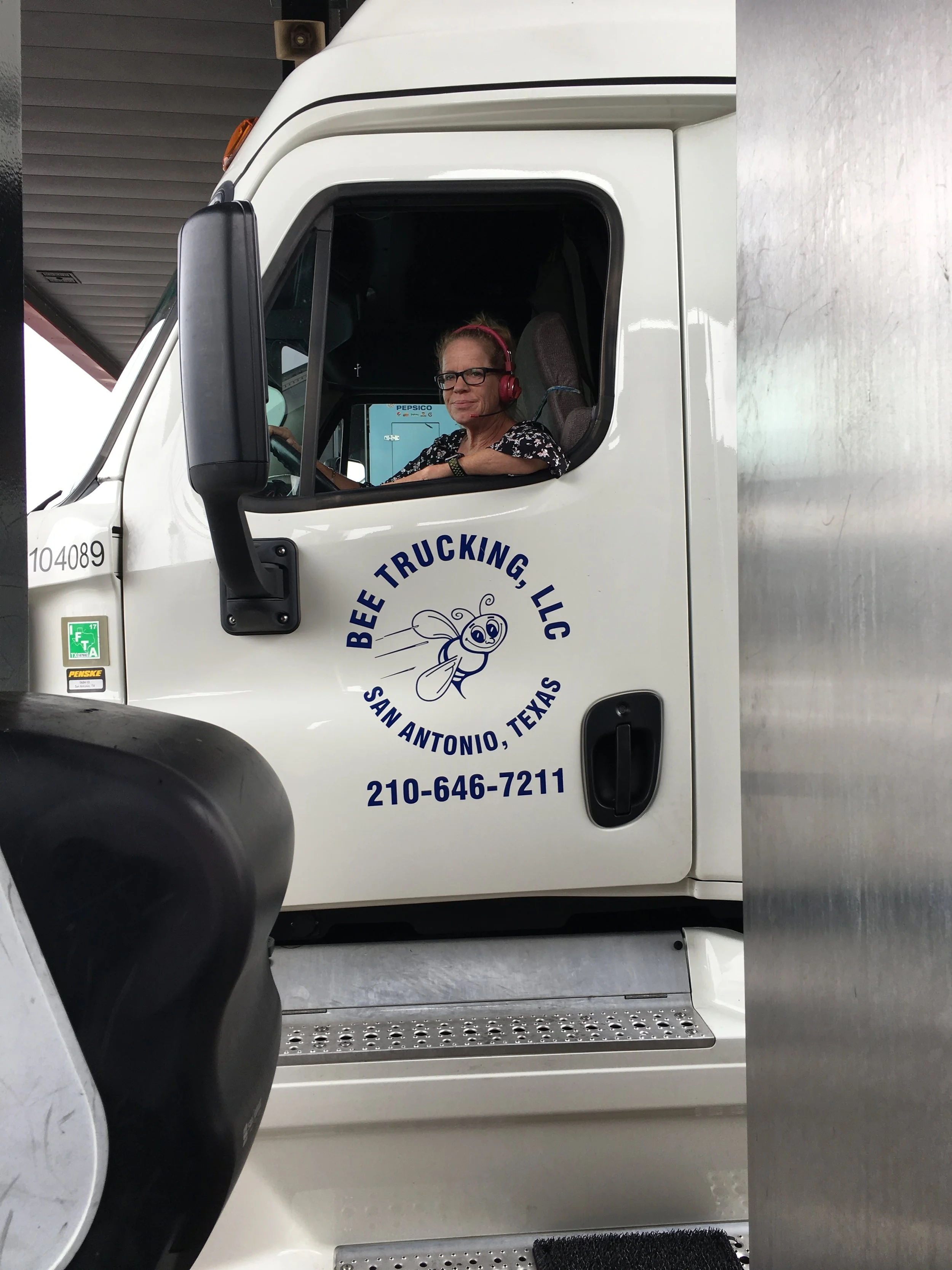  Anna listens while driving her 18-wheeler. 