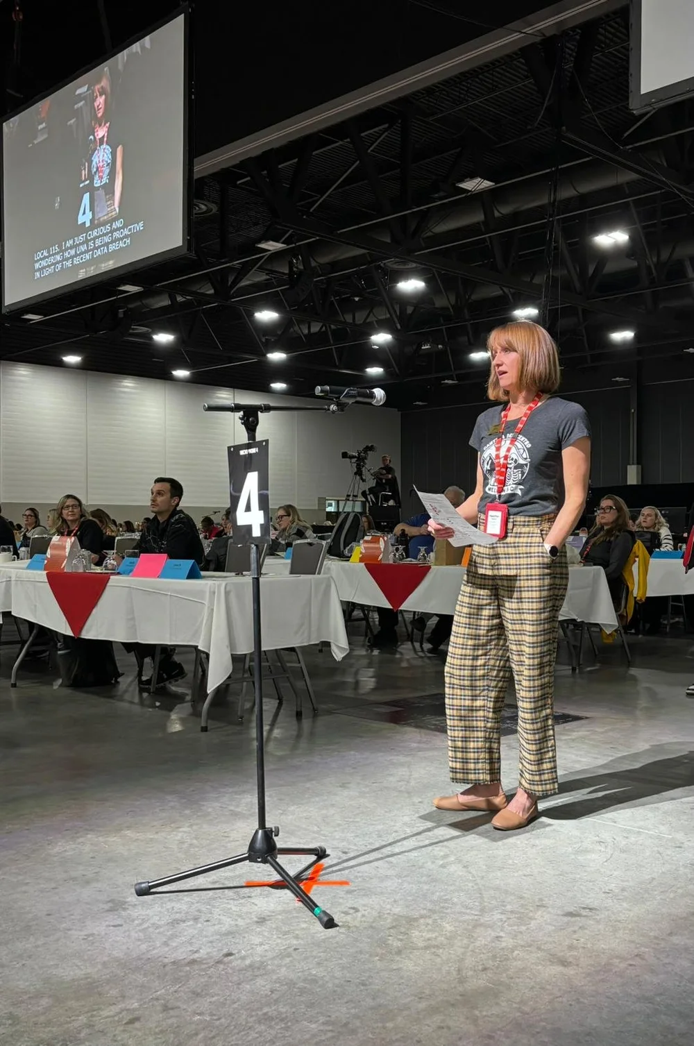  Local 115 Member Heather Haberli steps up to the mic to address the assembly at UNA’s 2025 Annual General Meeting 