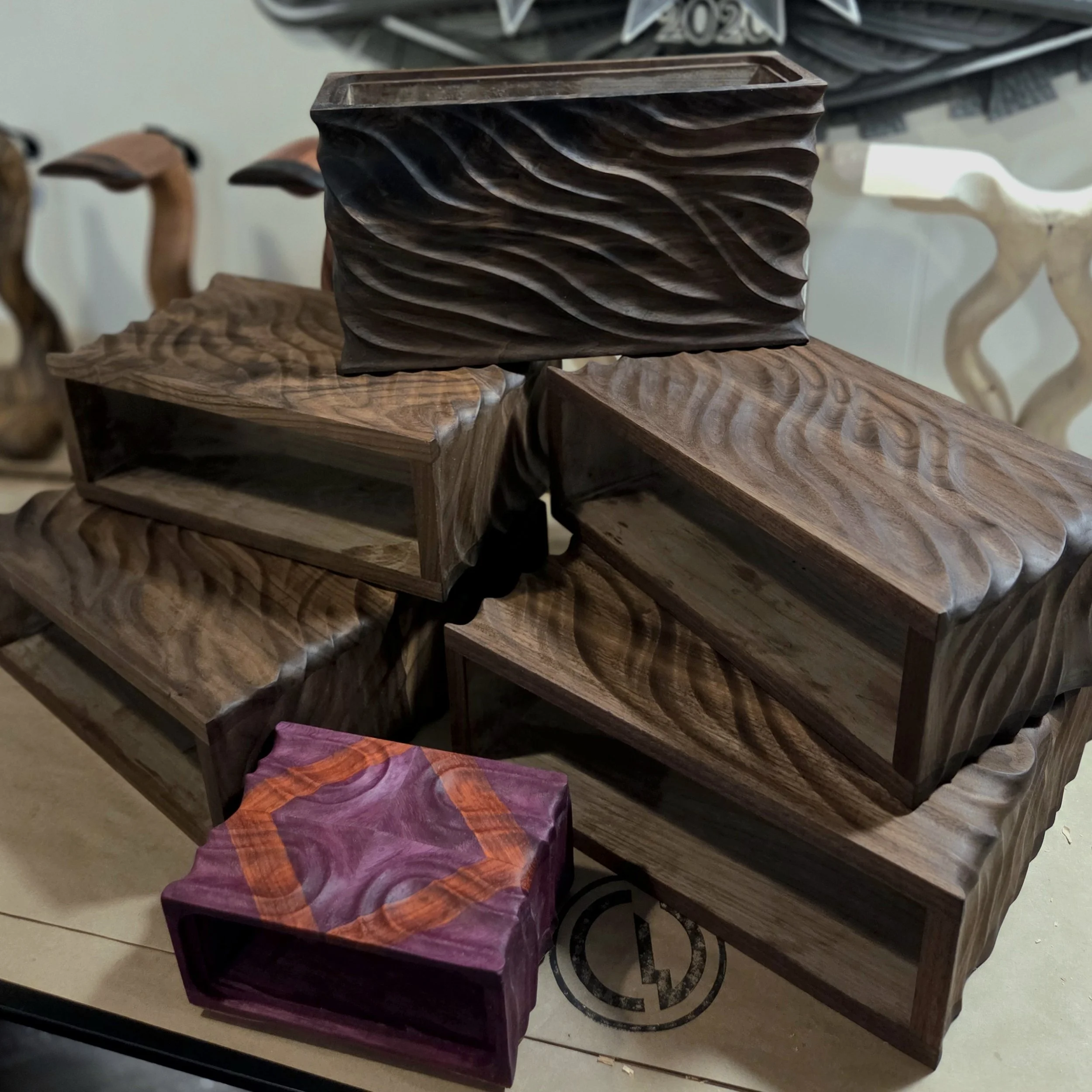 a stack of black walnut power carved Geshelli Labs Cases for Pre-Amps and DAC including a custom carved purpleheart and padauk J3 case