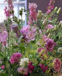 A vibrant and colorful hand-tied floral bouquet featuring purple and pink blooms, created during a signature workshop at the Covent Garden Academy of Flowers