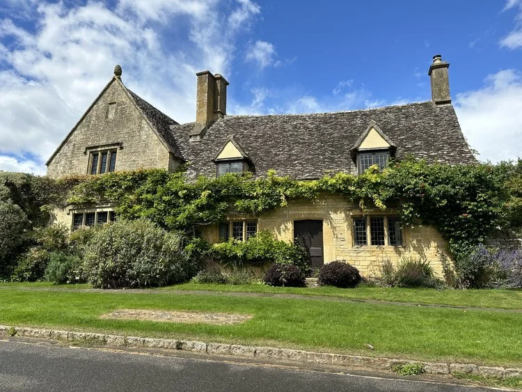 A charming traditional Cotswold stone cottage surrounded by greenery in Chipping Campden, marking the gateway to the Cotswold Way trail