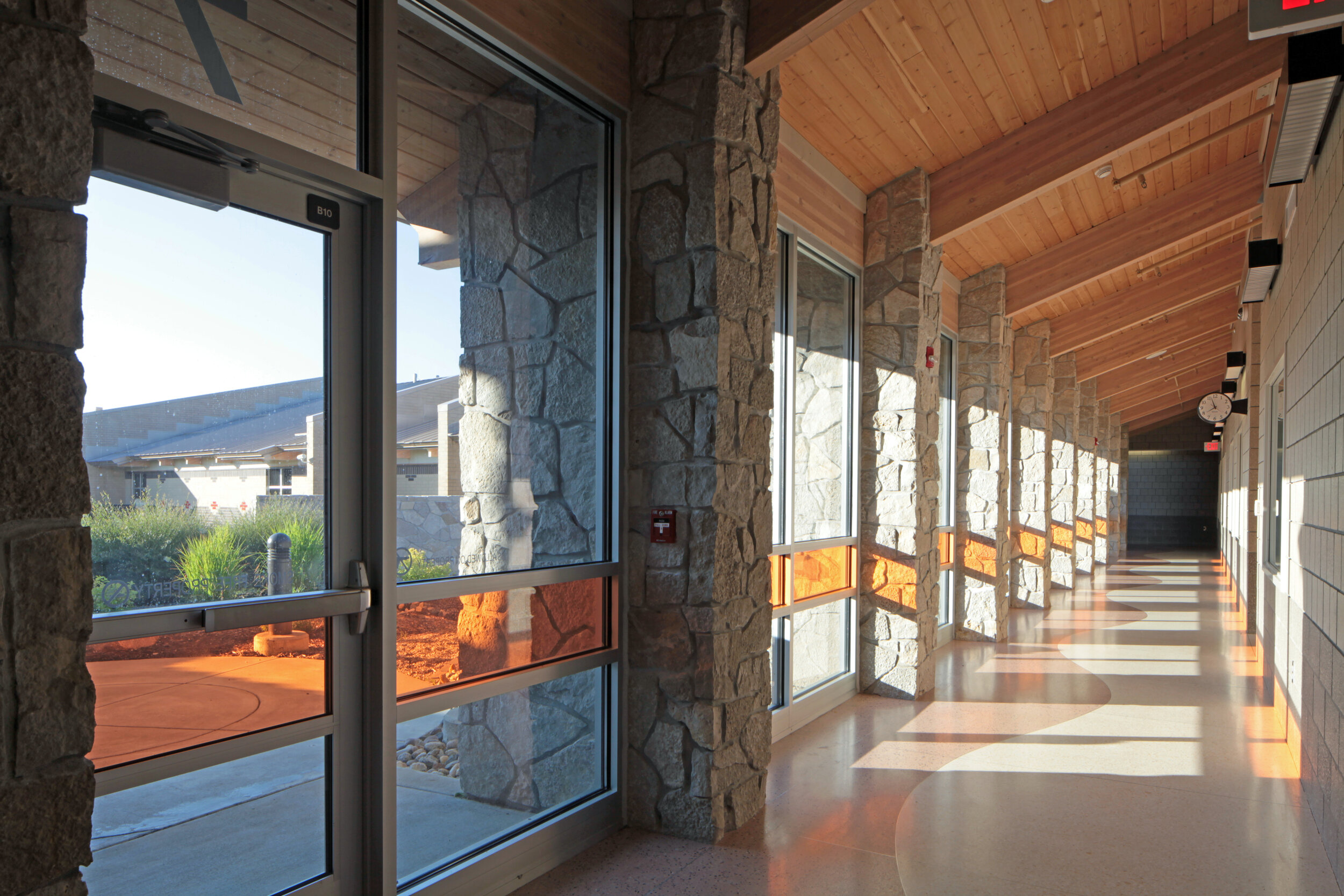 Color-tinted windows illuminating an interior corridor at Circle of Life Academy in White Earth MN
