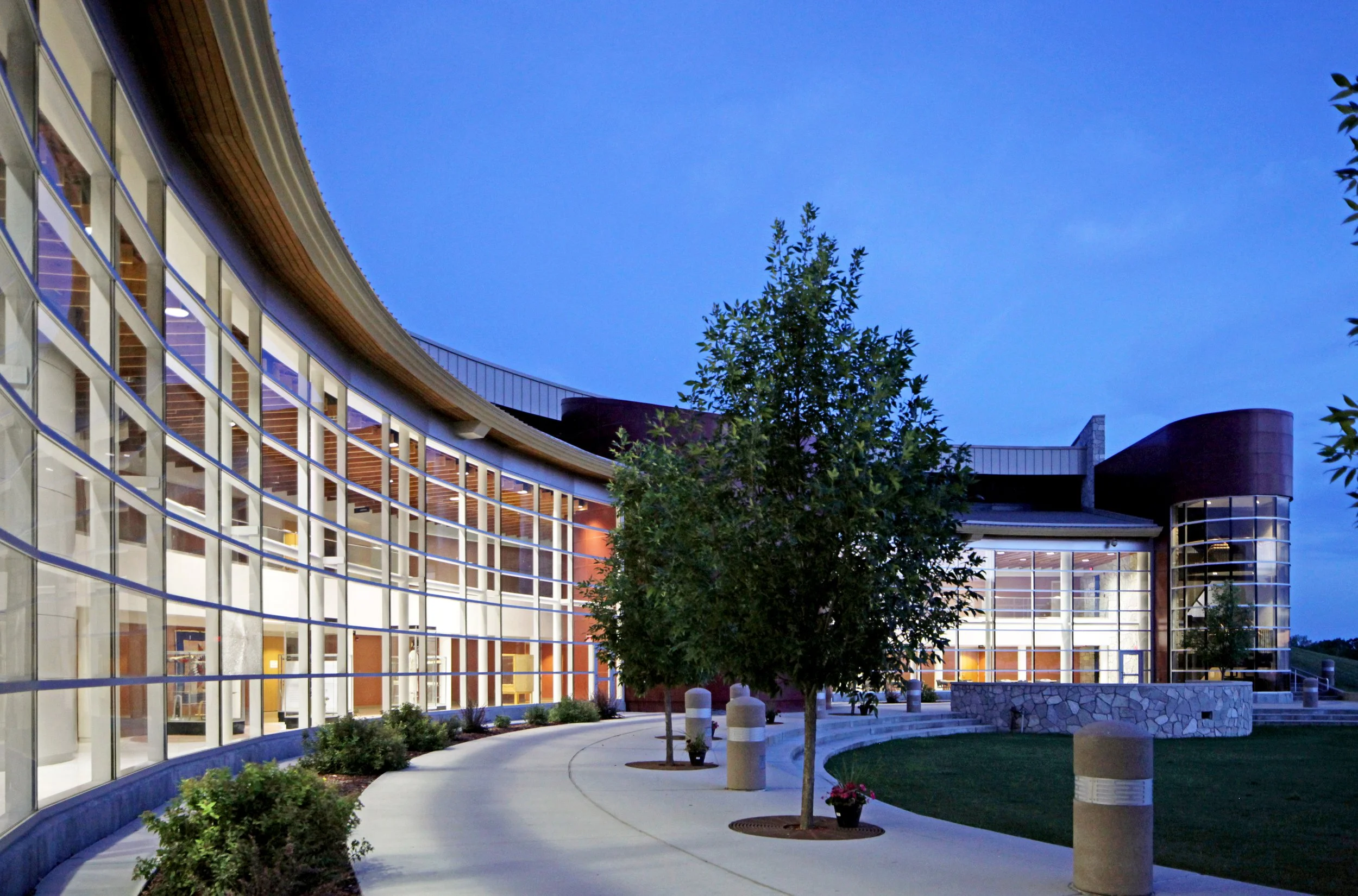 Exterior night perspective of curved storefront at White Earth RTC Headquarters in Ogema MN