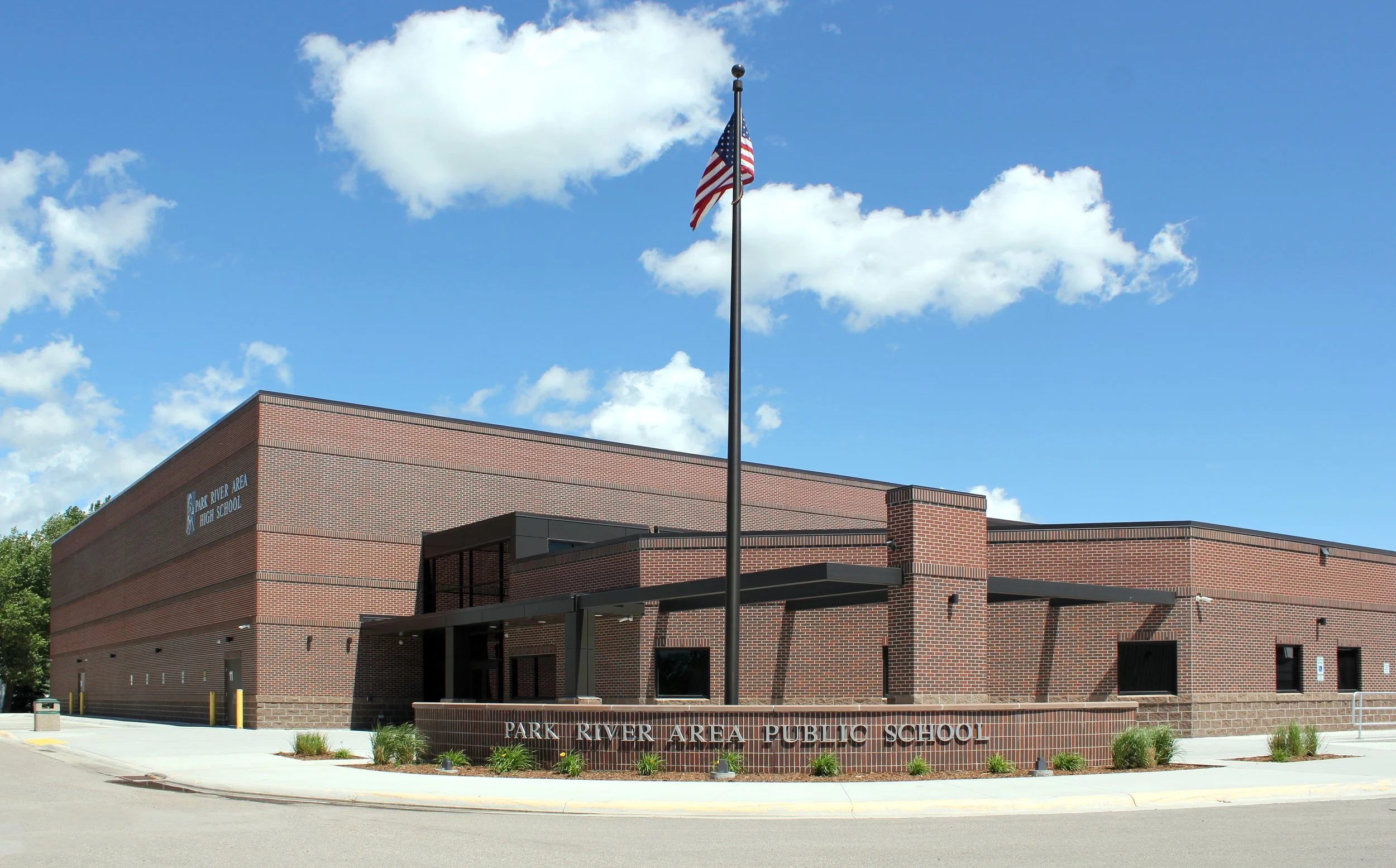 Exterior perspective of Park River Public School with flag and signage in Park River ND